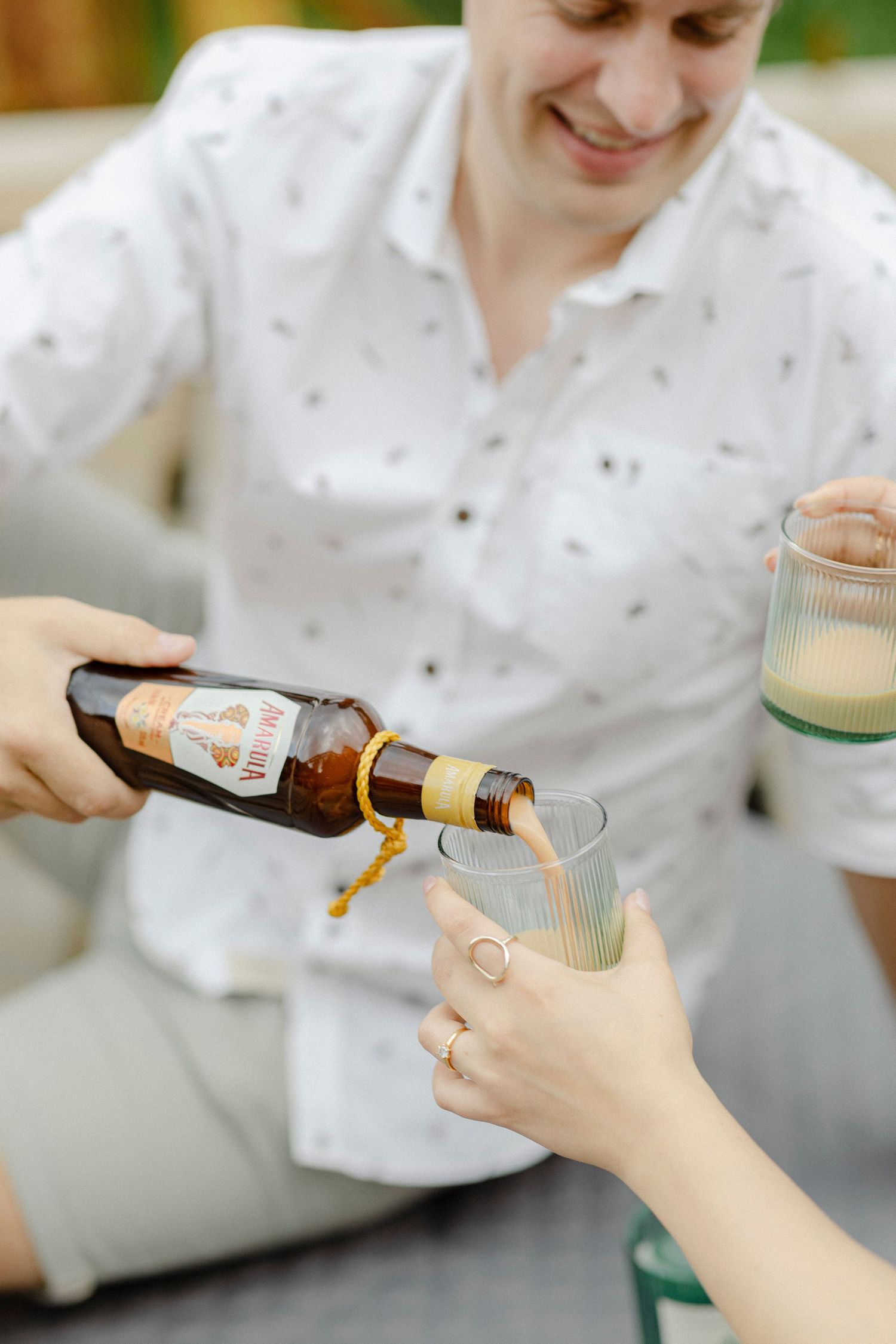 A woman pours Lagunitas beer into a glass while a smiling man in a white shirt holds a drink outdoors.