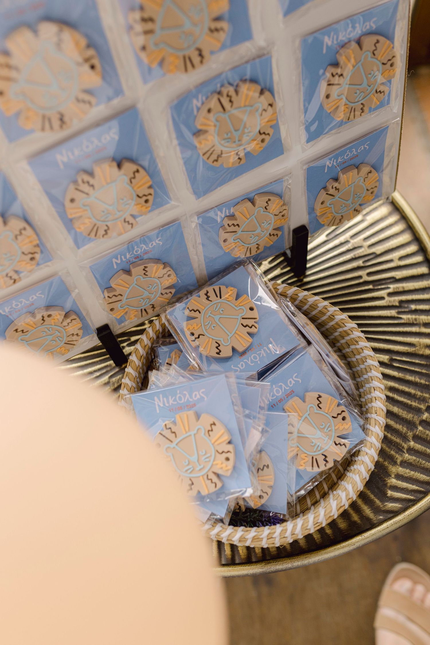 Blue and gold packaged wedding favors displayed in a decorative metal basket and arranged on a tray.