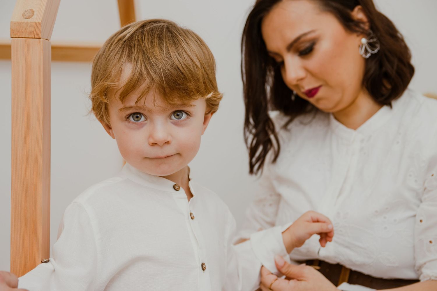 Fotografia de batizado, mãe a vestir menino. Viana do Castelo