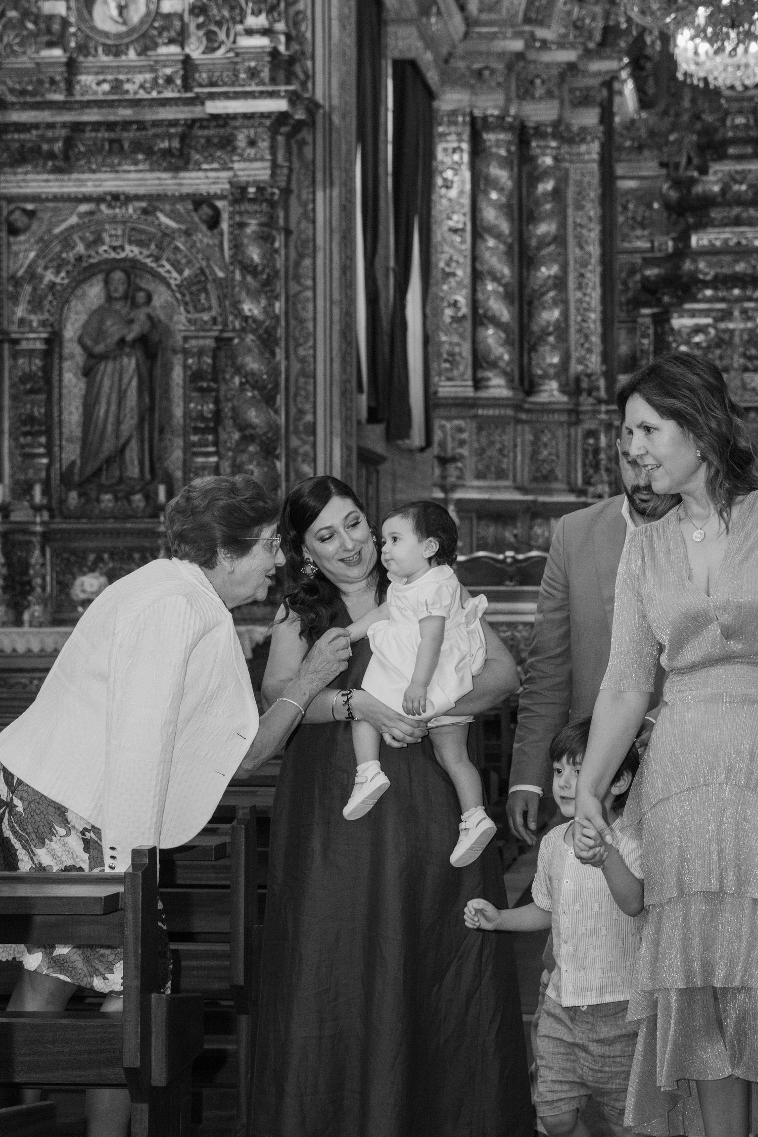 Fotografia de batizado. Bebé no colo da mãe dentro da igreja. Maia
