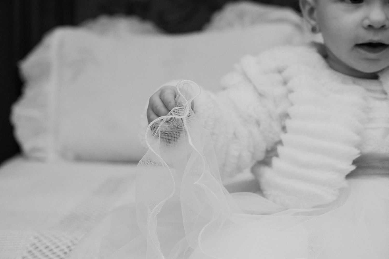 Fotografia de batizado. Pormenor do bebé a segurar no vestido. Gião, Vila do Conde