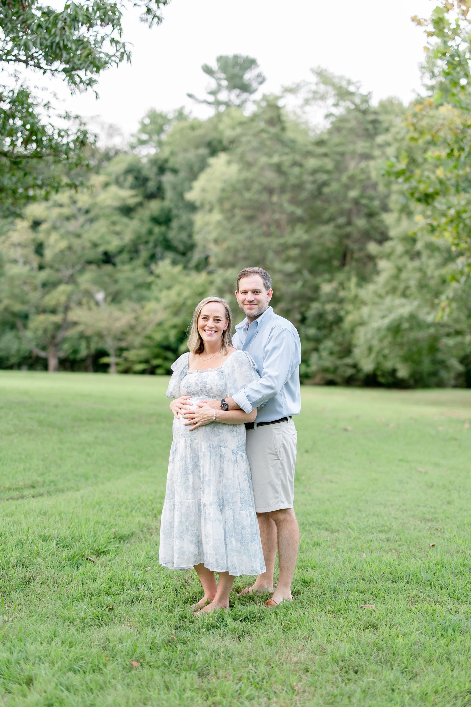 A loving family embraces during their outdoor photo session in coordinated outfits.