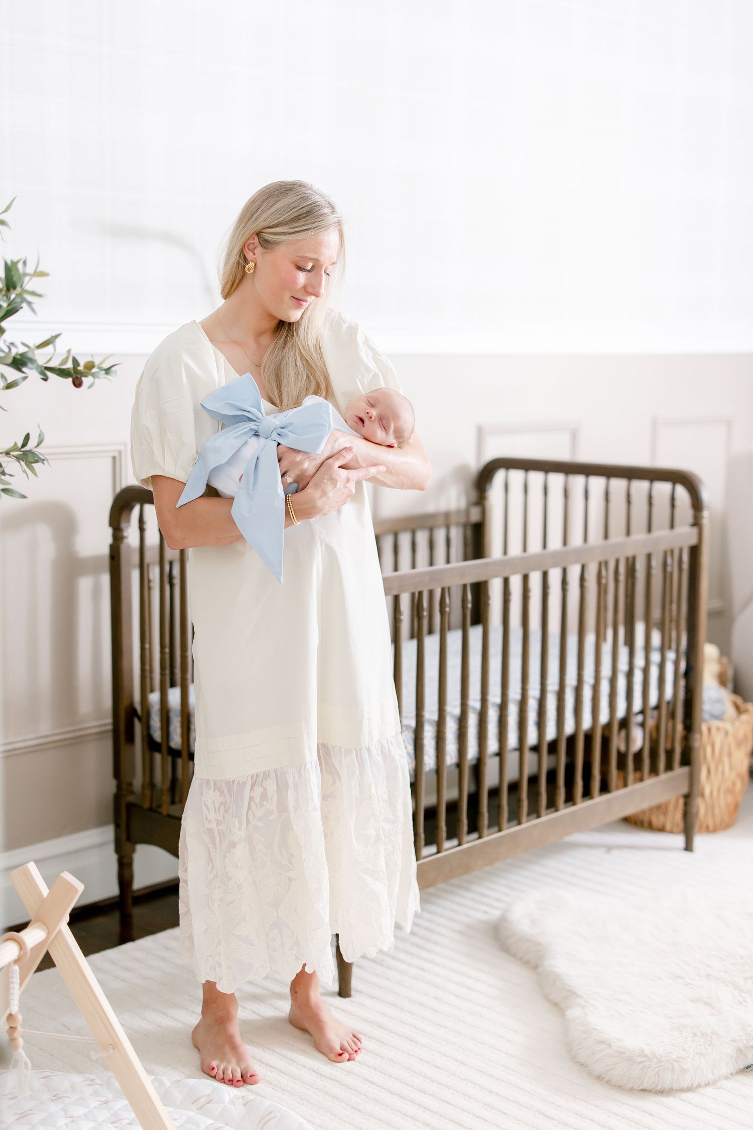 Nursery scene with dark wood crib, white walls, and natural lighting.