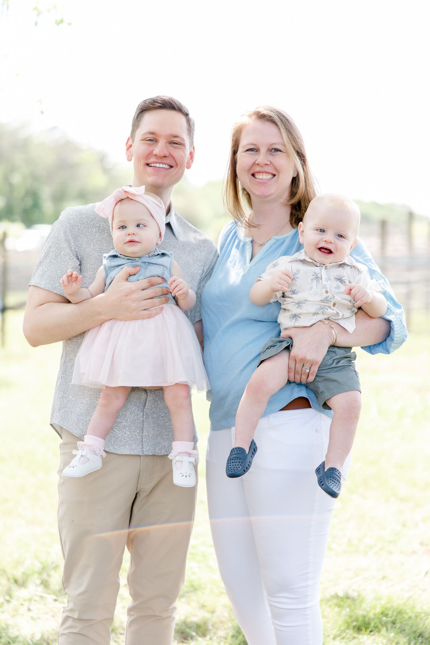 Family portrait outdoors in casual attire on a sunny day.