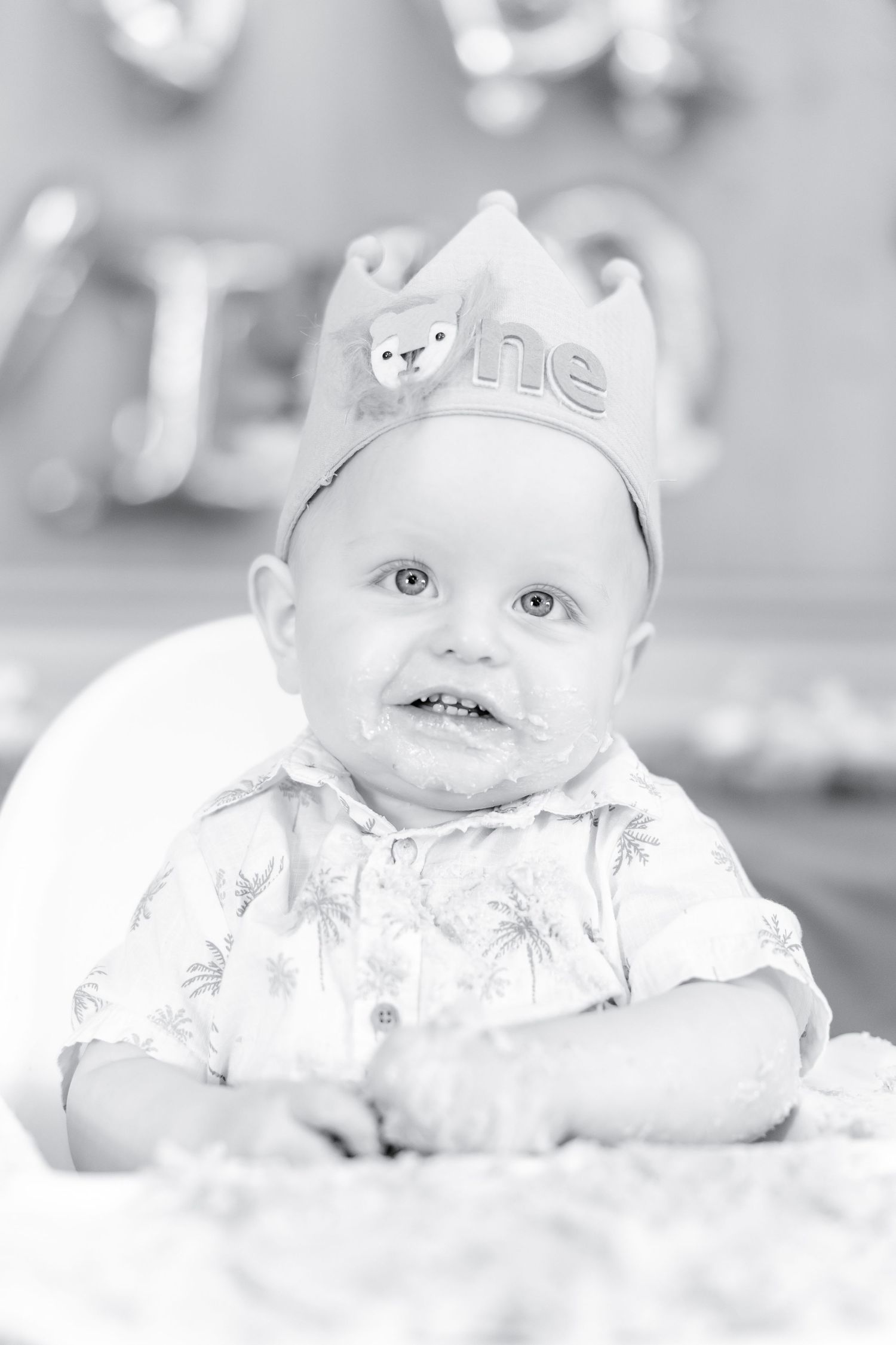 Black and white portrait of baby wearing crown with fox detail.