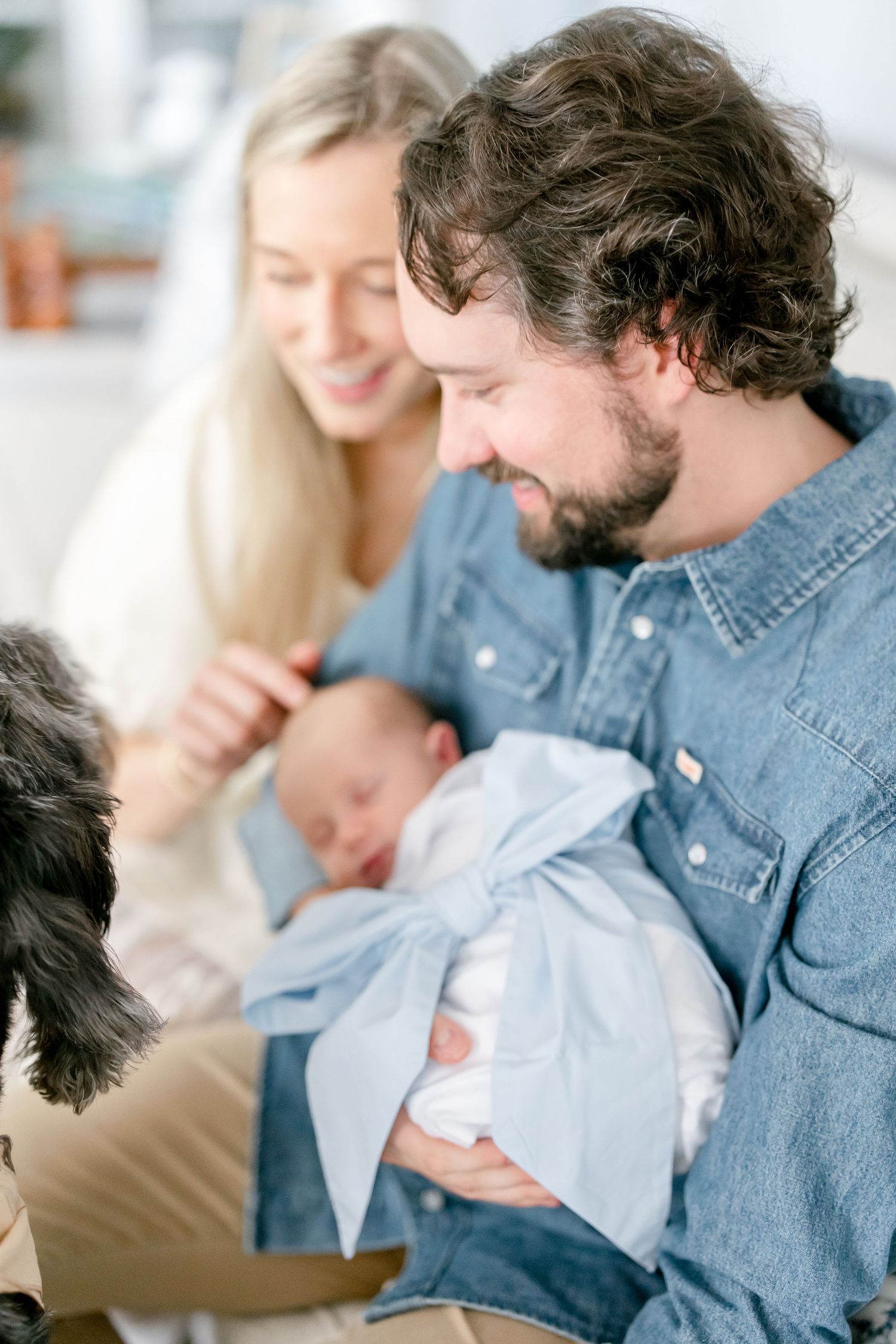 A tender moment captured in sequence showing a person in denim holding a newborn baby swaddled in white.