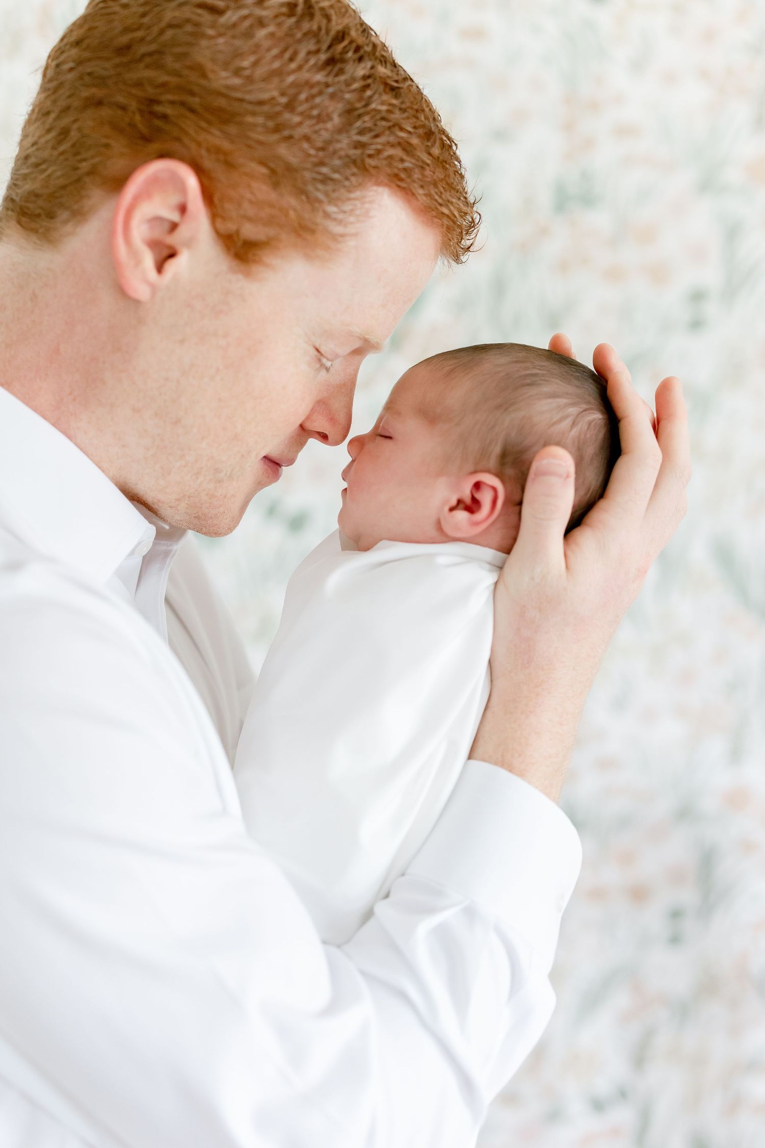A tender moment between parent and newborn in soft natural light.