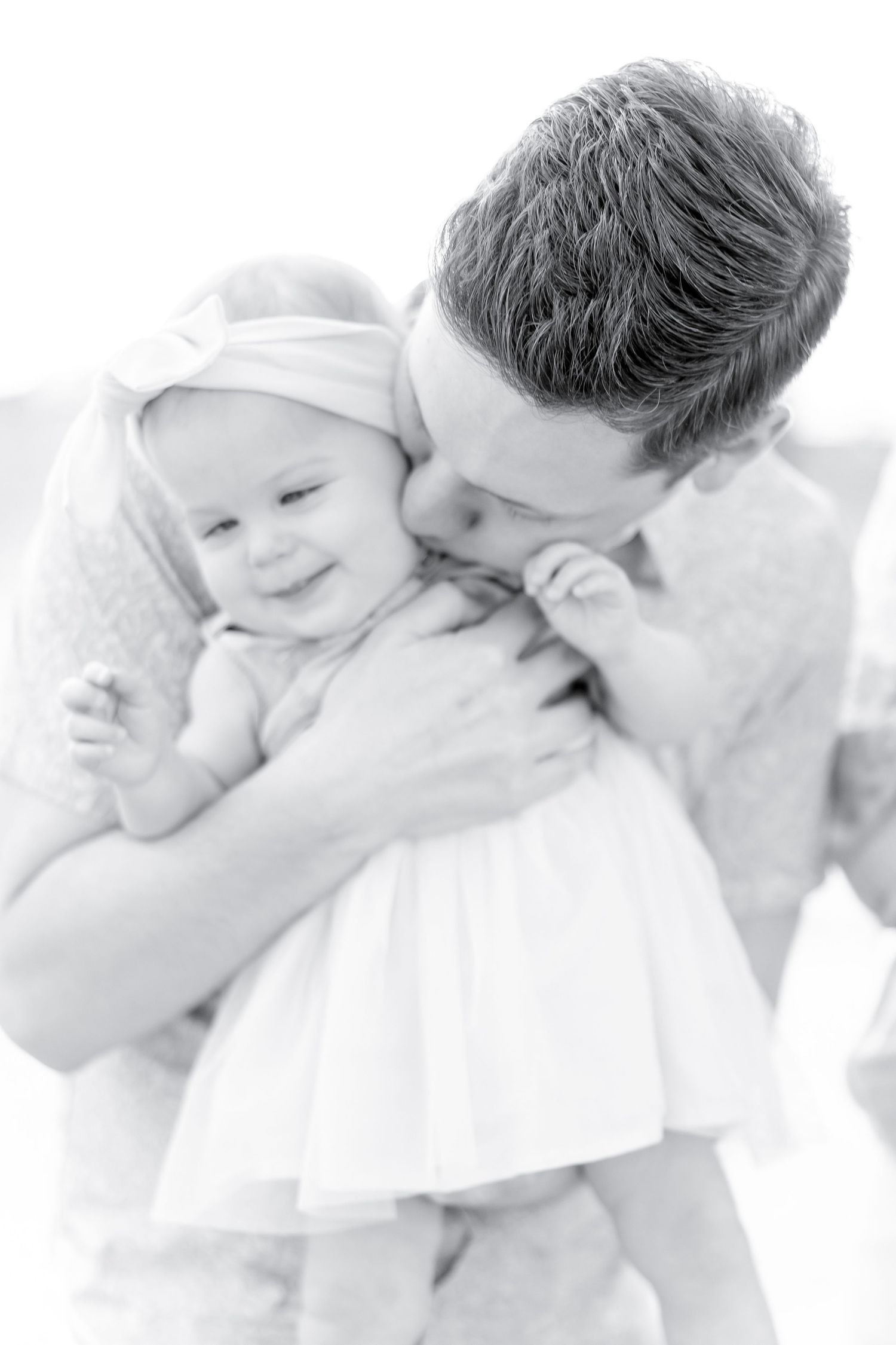 Black and white intimate portrait of a parent and baby sharing a tender moment together.