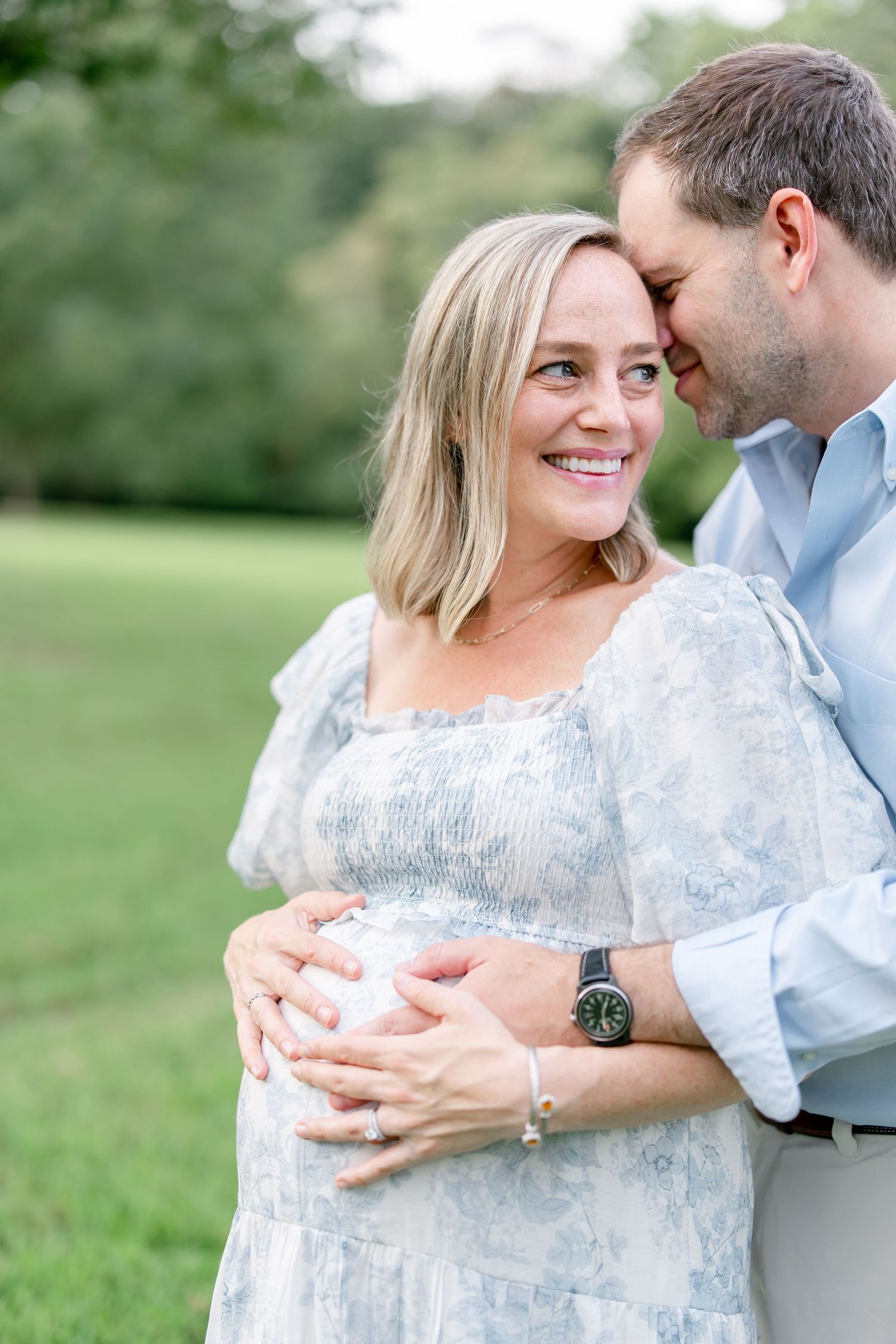 Tender moment captured in an outdoor setting with soft natural lighting.
