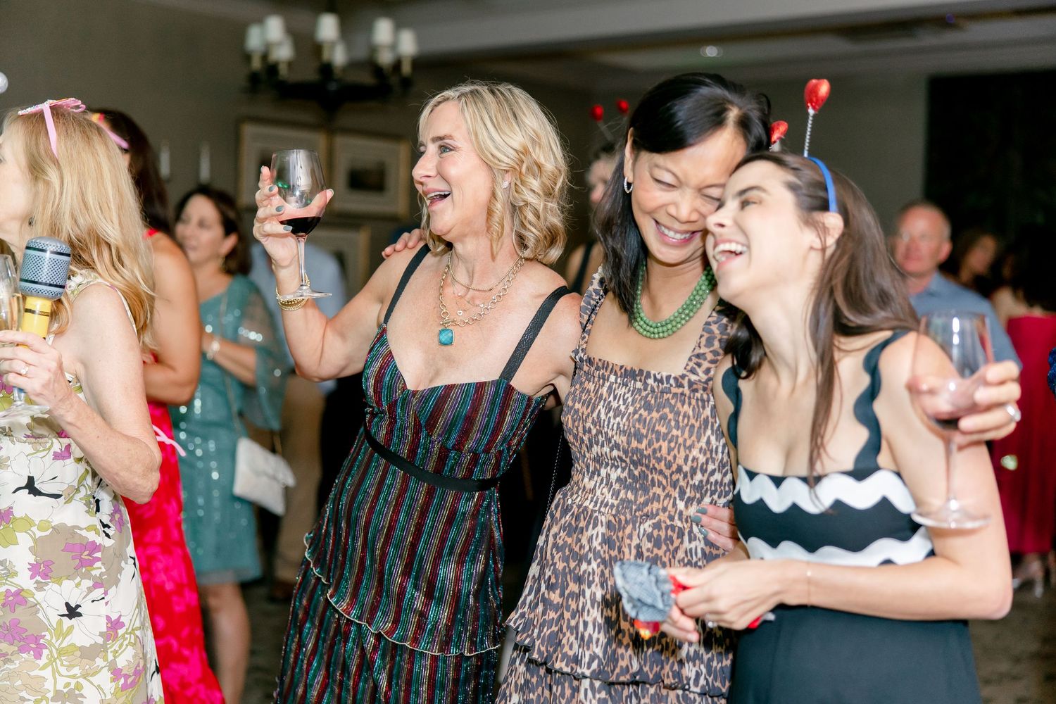 People socializing and enjoying drinks at an indoor party event.