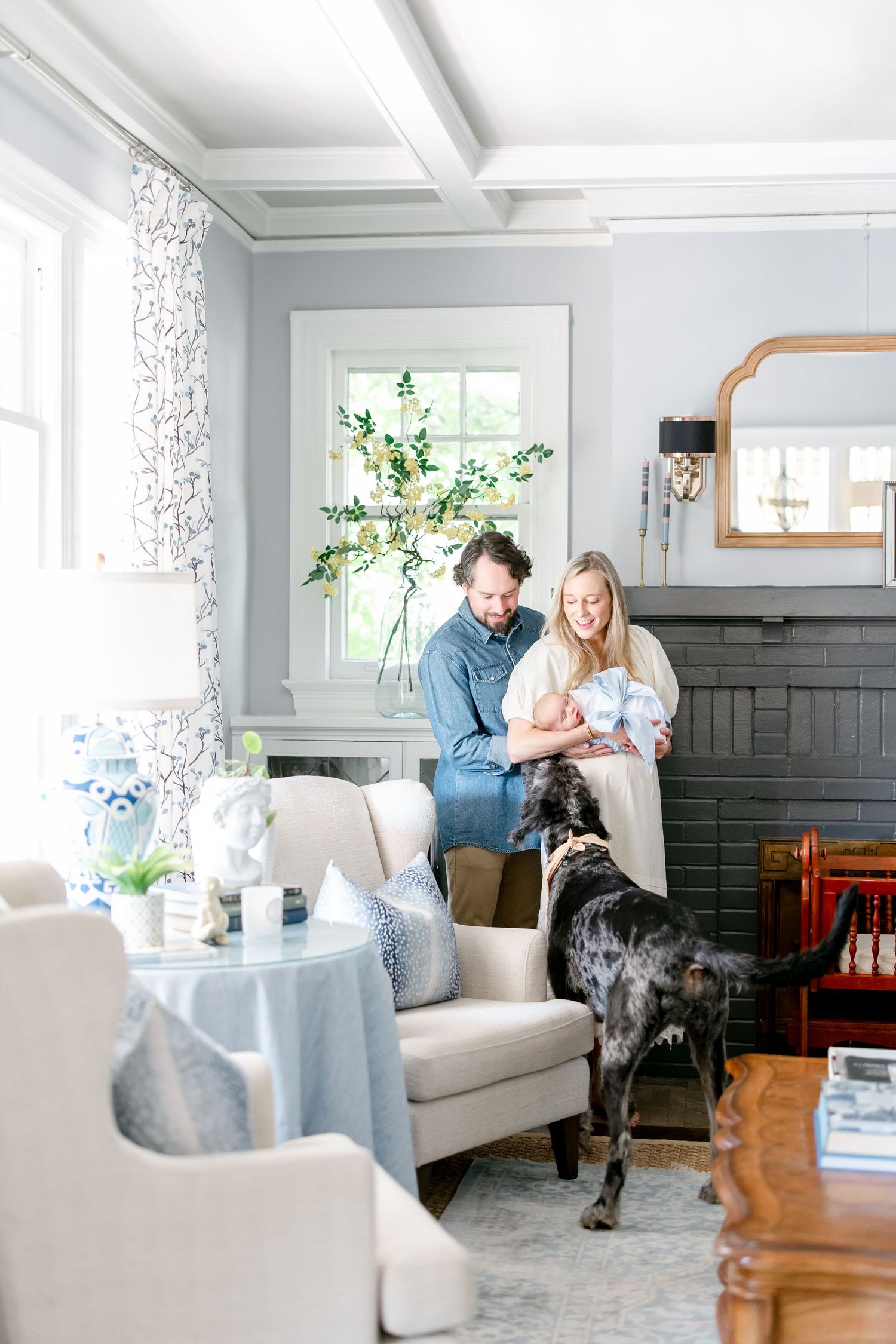 A family enjoying quiet moments together in their living room with dogs on a white couch.
