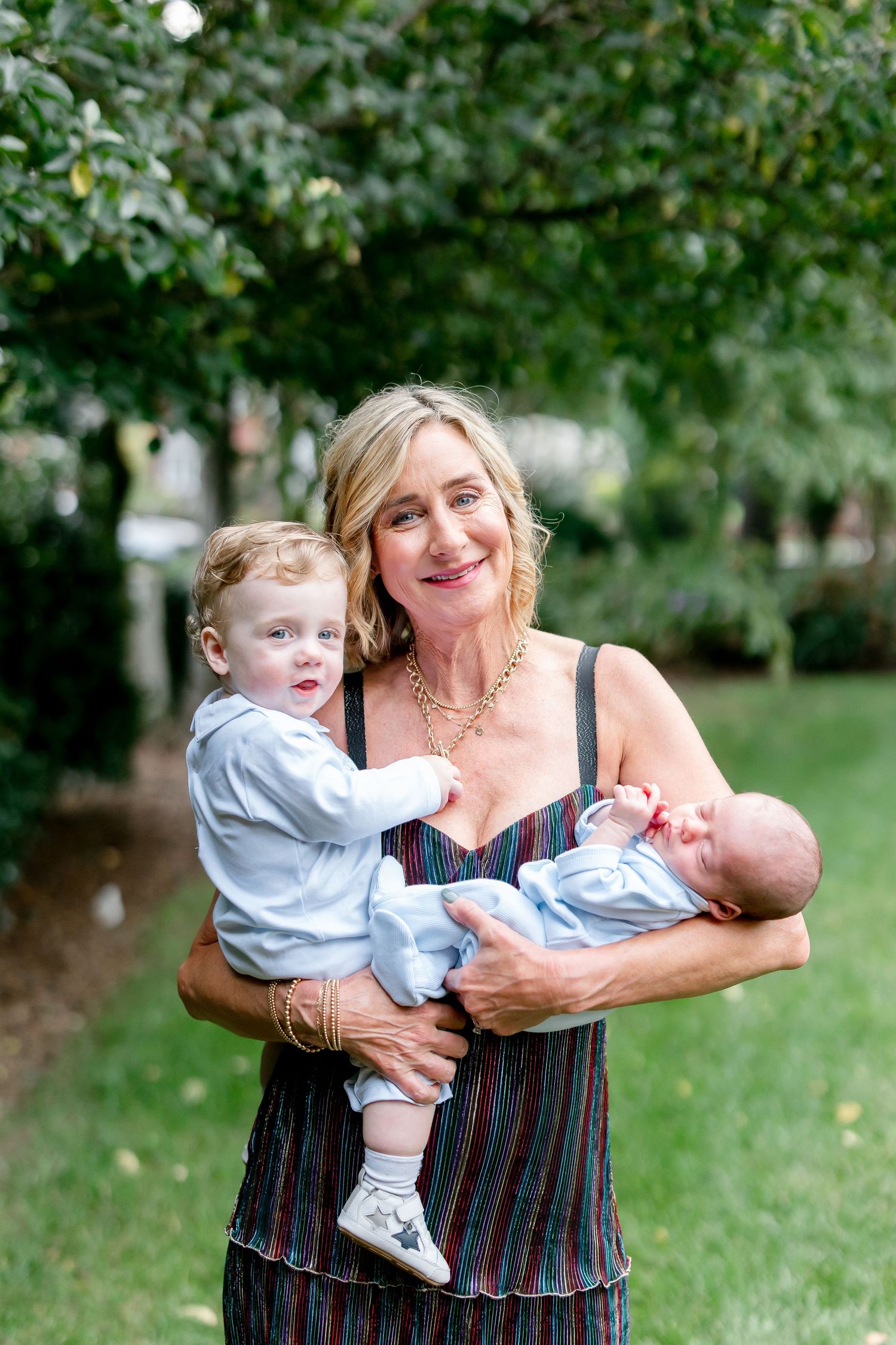A series of candid outdoor photos showing playful interactions with a baby in a light blue outfit on a grassy lawn.