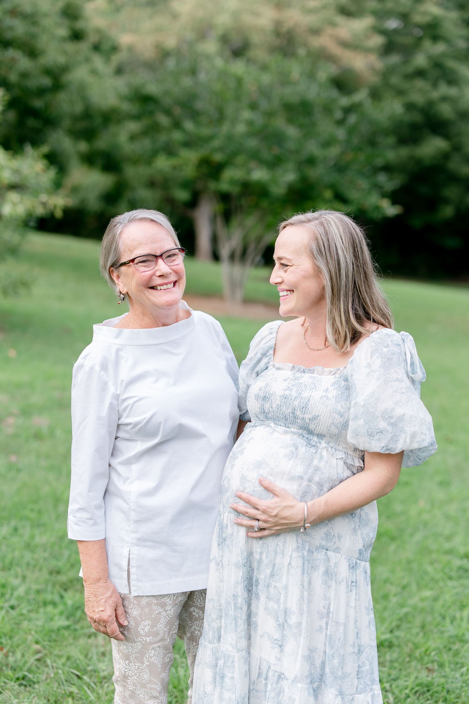 Happy family moment captured outdoors with coordinating white and blue outfits.