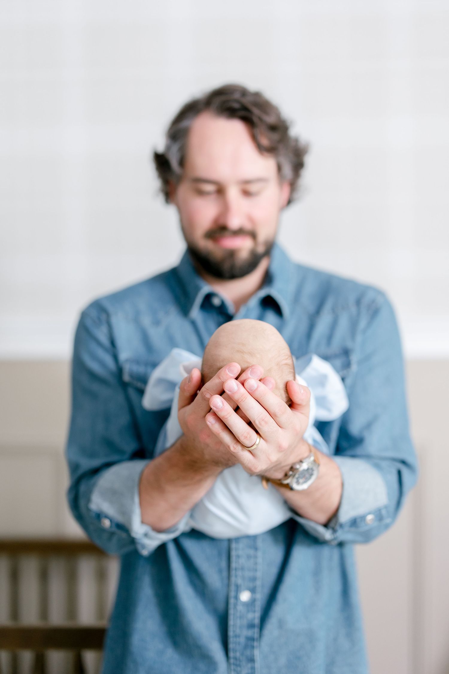 Collection of cropped photos showing someone in denim shirt holding and examining a piece of white cloth with gentle hands.