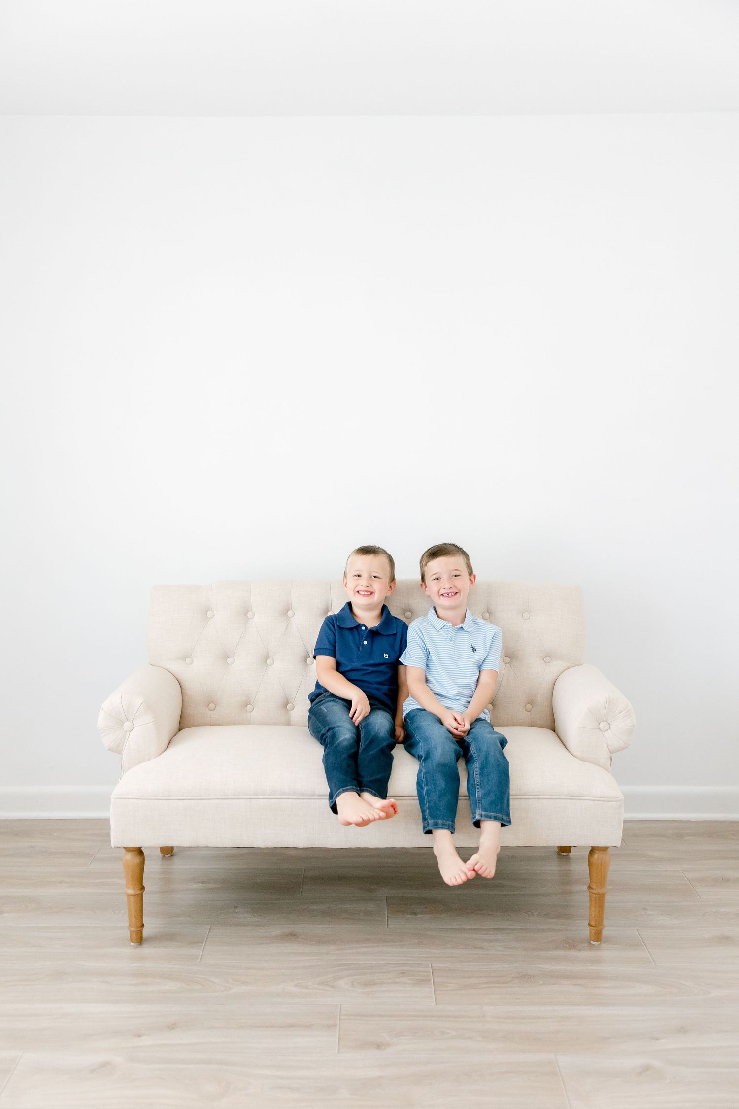 Three progressive photos show two people sitting together on a cream tufted sofa against a white wall.