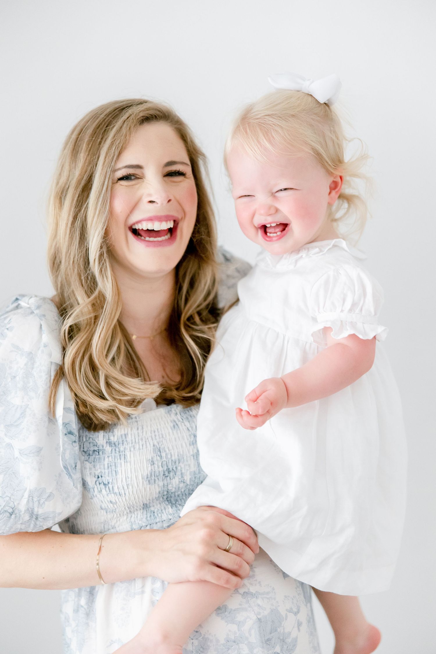 Pure joy captured in a bright white studio portrait showing shared laughter and happiness.