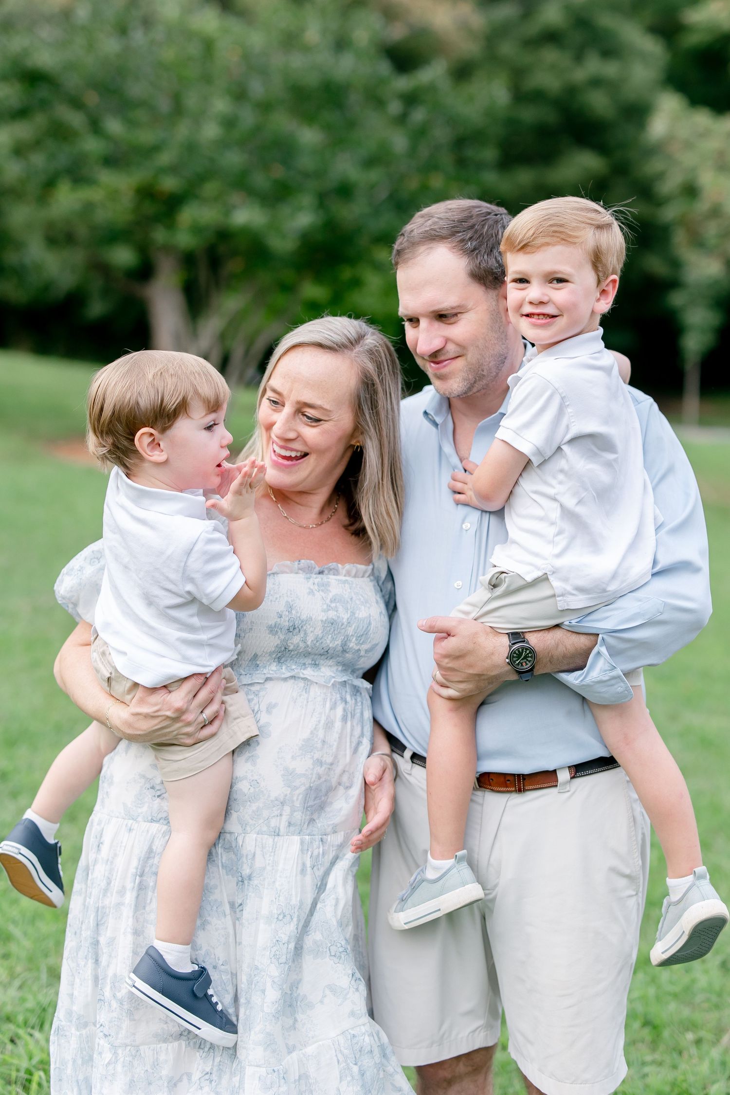 Candid family photo showing playful interactions and laughter in an outdoor setting.