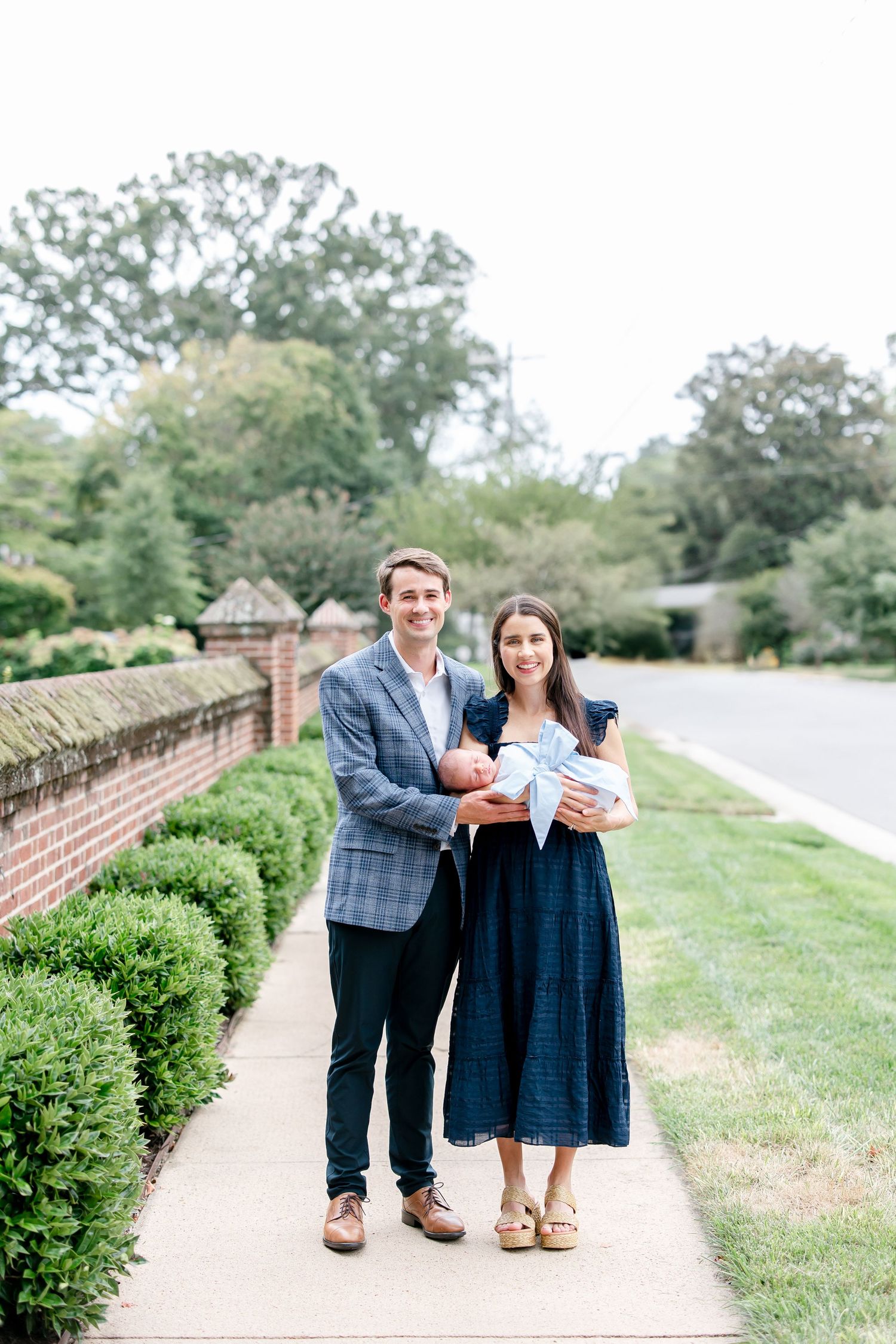 A gentle moment captured along a brick-lined garden path showcases a romantic outdoor portrait session.