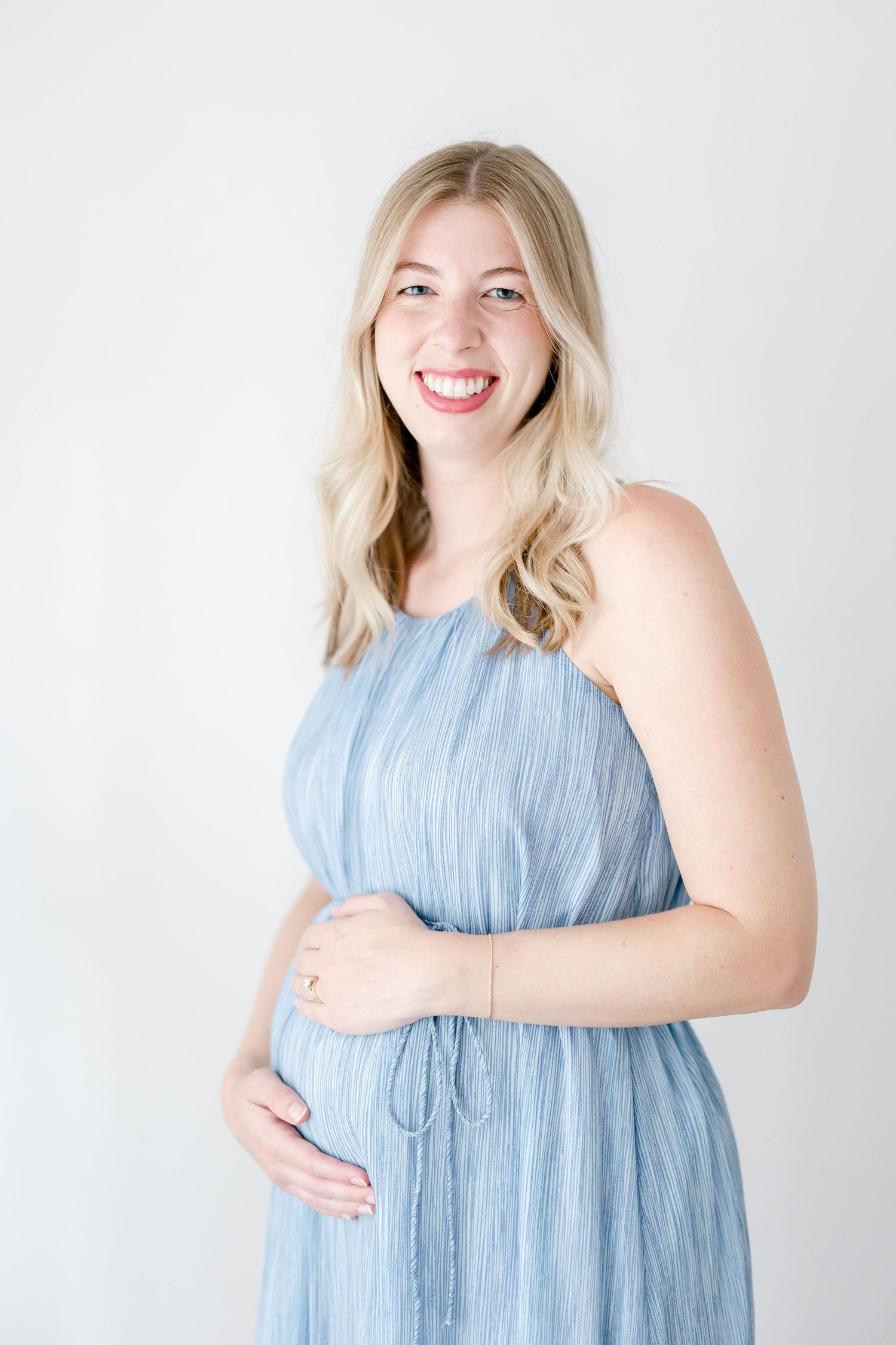 Four connected images show someone wearing a flowy light blue summer dress against a white background with joyful expressions.