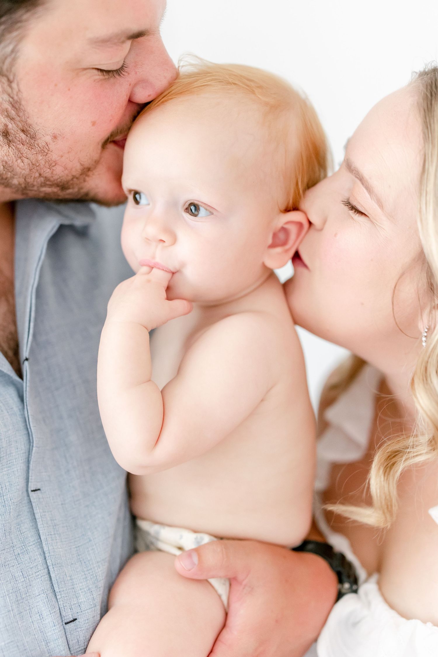 A tender moment captured in a series of intimate family portraits against a light background.