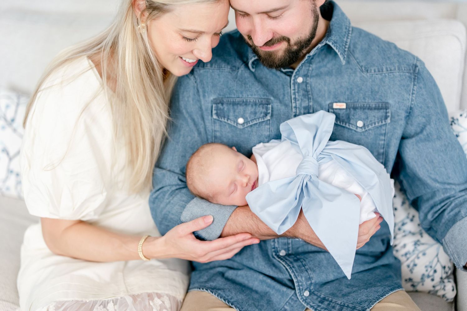Family photo session in bright room with white and denim clothing.