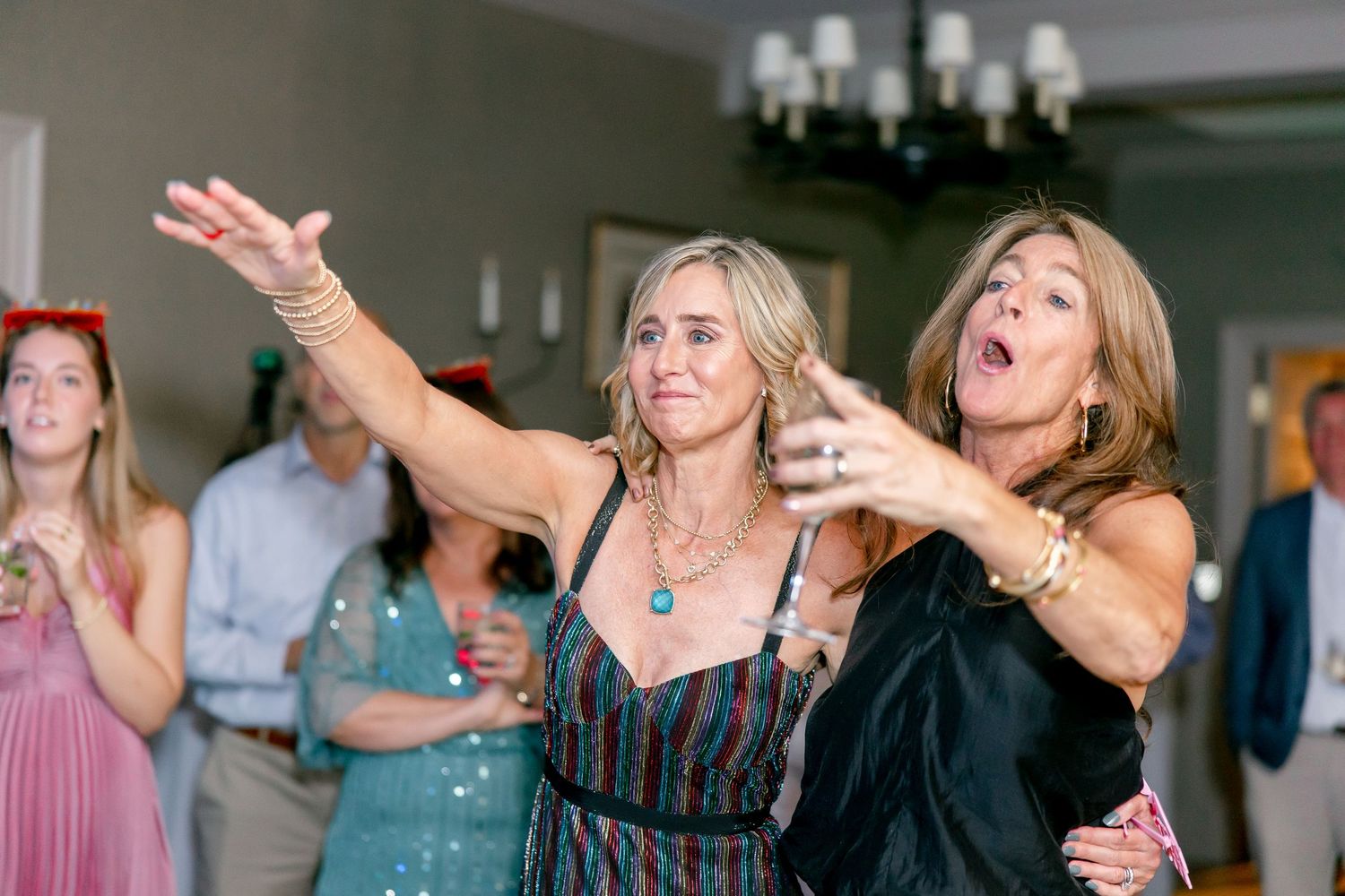 Guests enjoying themselves at a celebratory indoor event with dramatic lighting and entertainment.