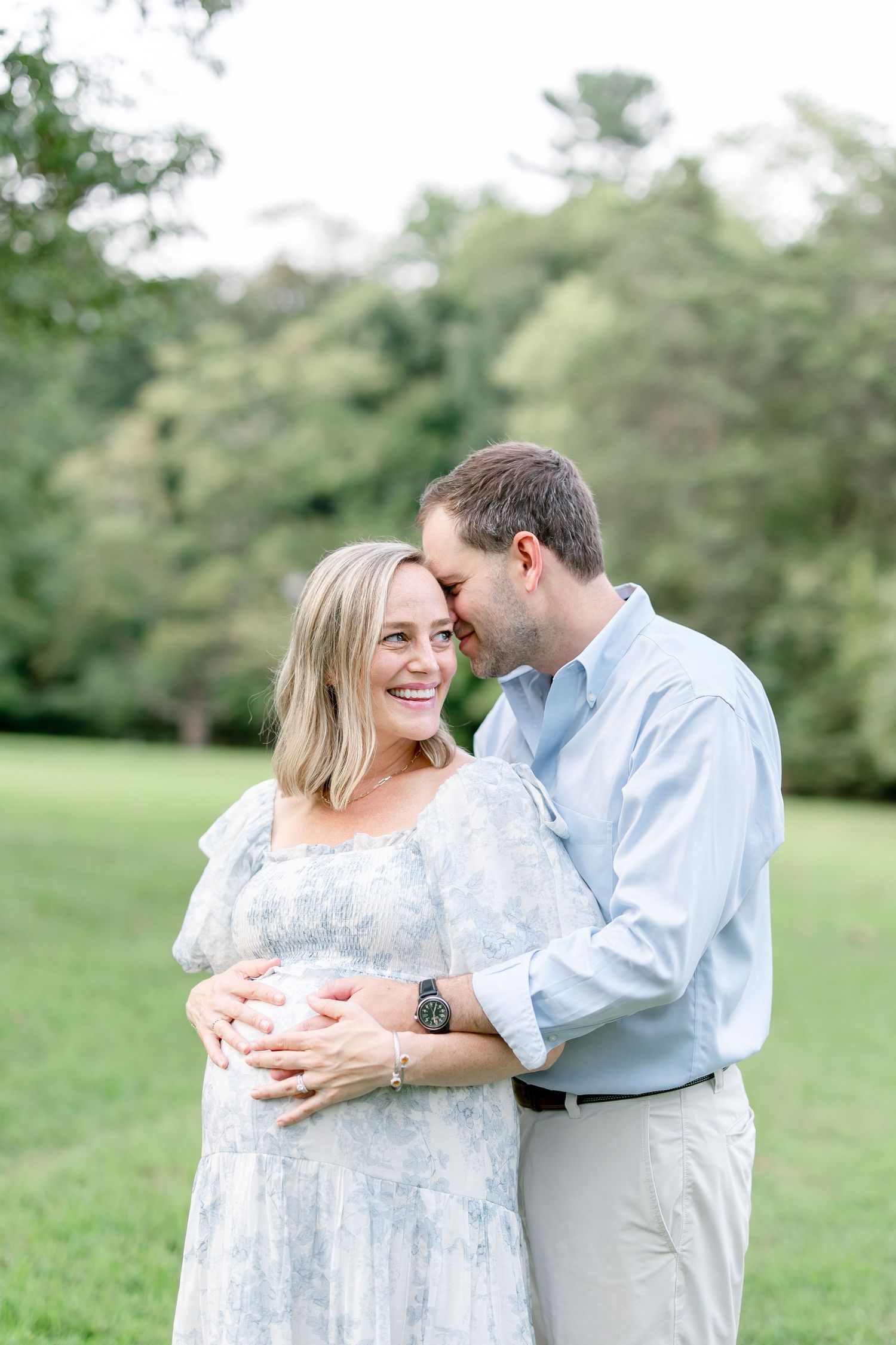 A romantic couple sharing tender moments together in a serene park setting.