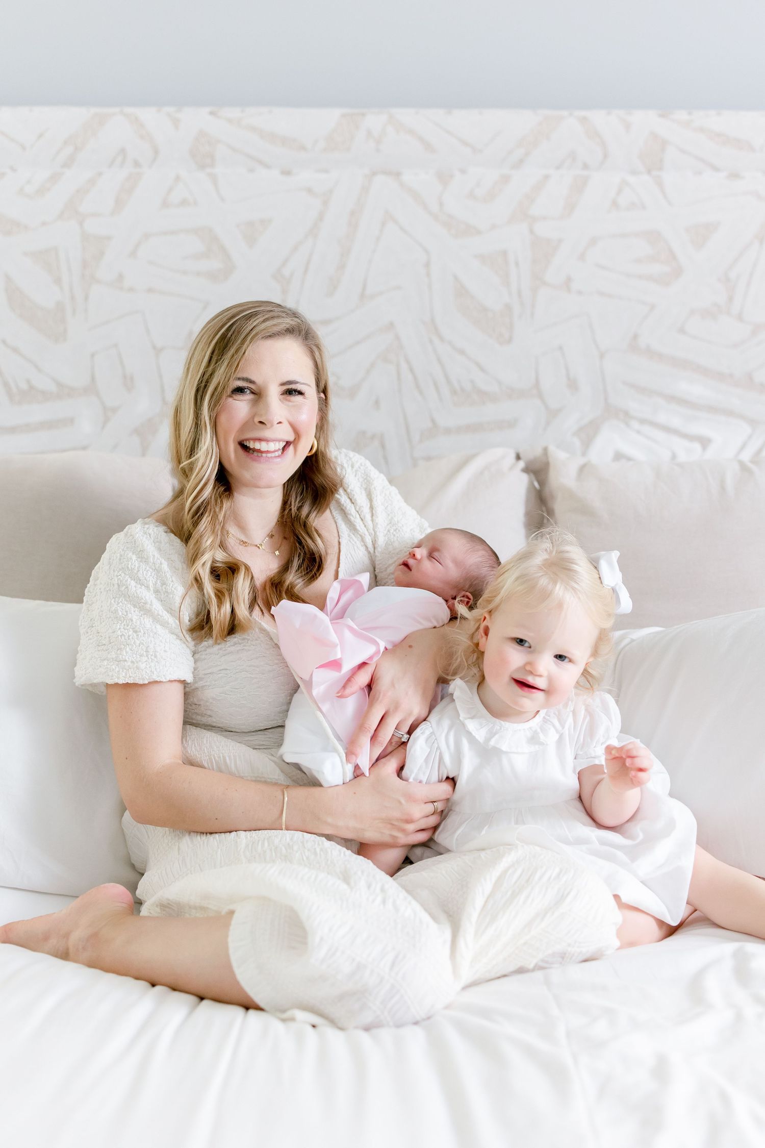 A family relaxing together on a white couch with coordinated outfits.