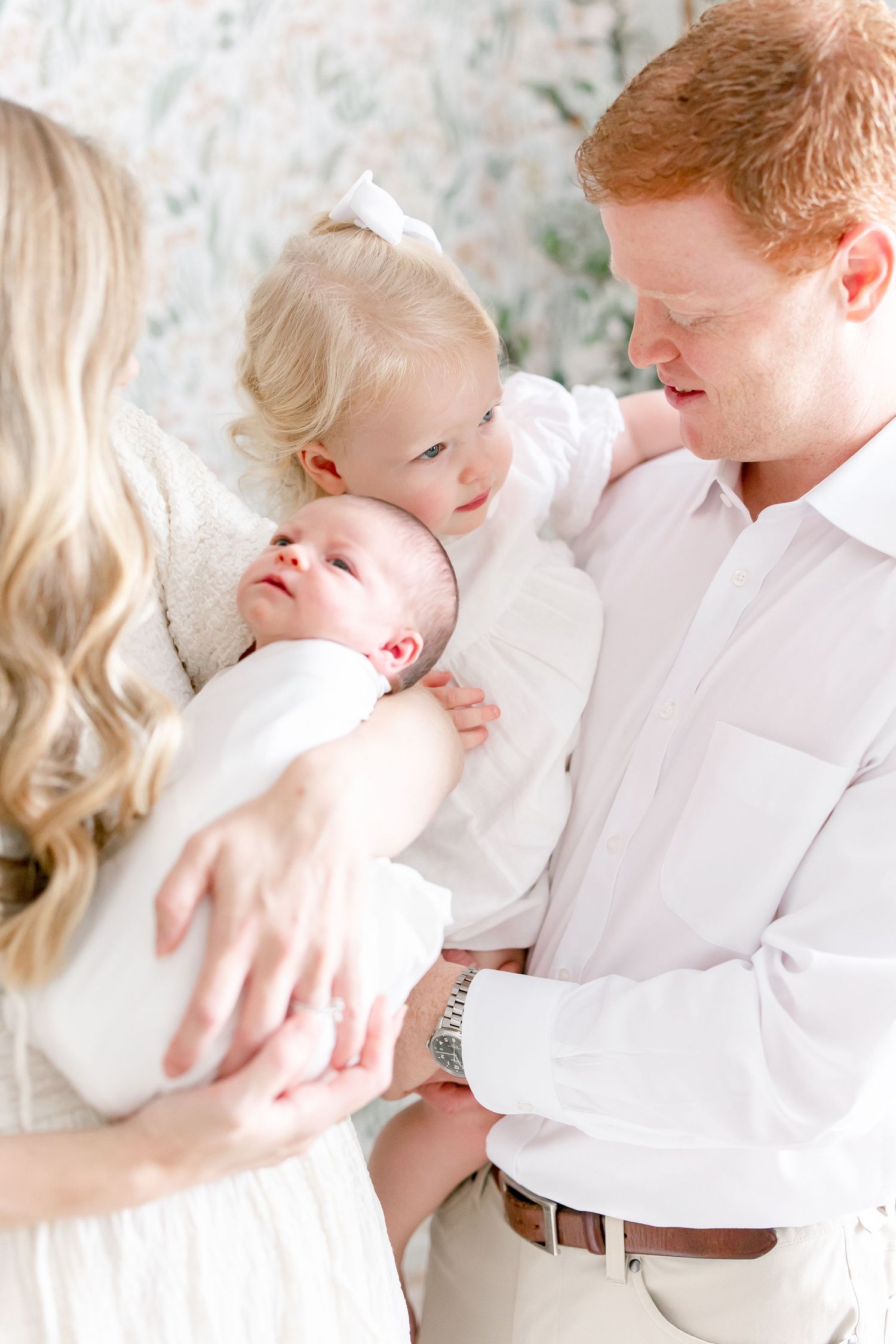A tender family moment captured in soft light as they gather around their newborn.
