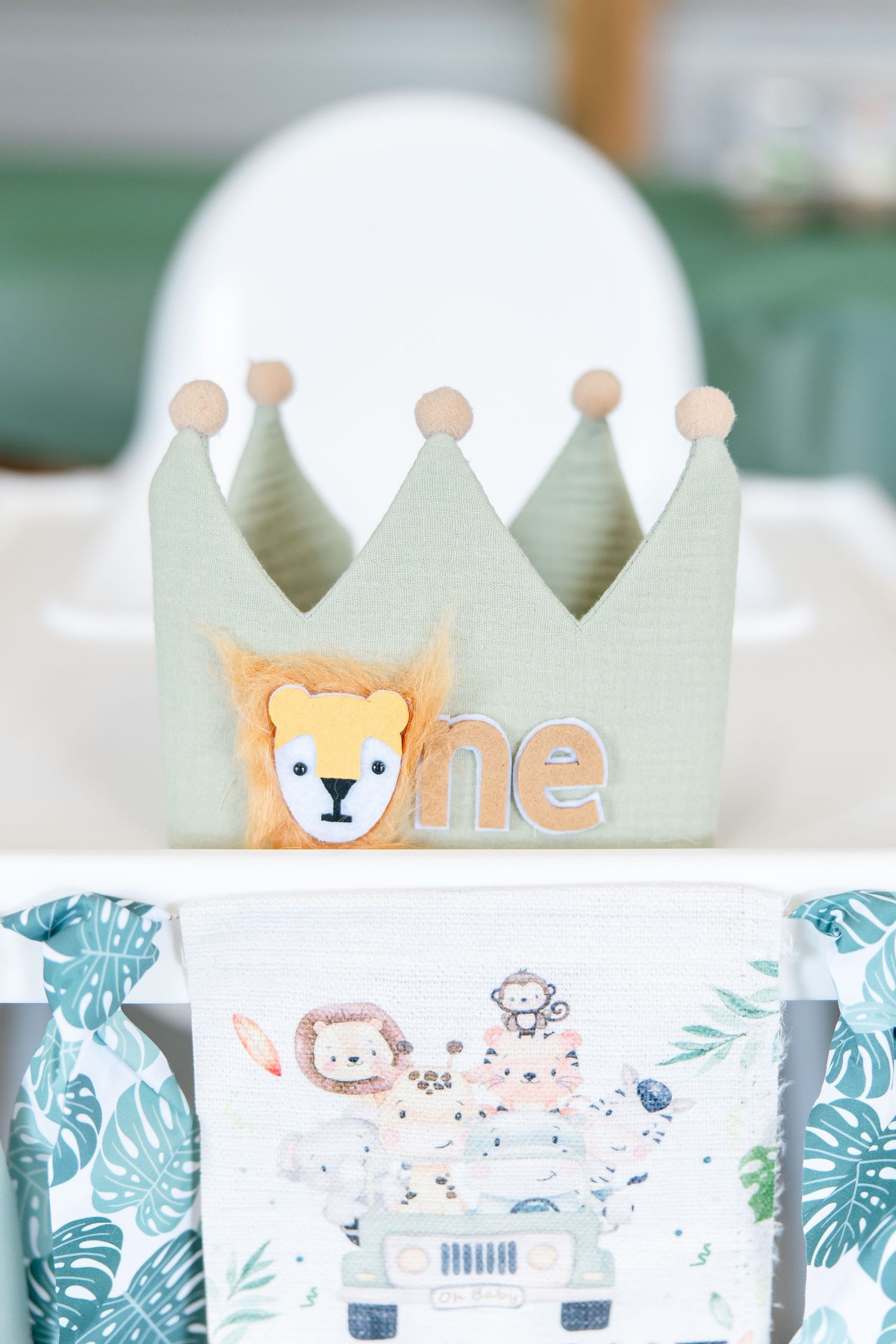 Mint green birthday crown with lion design and 'one' text for first birthday celebration.