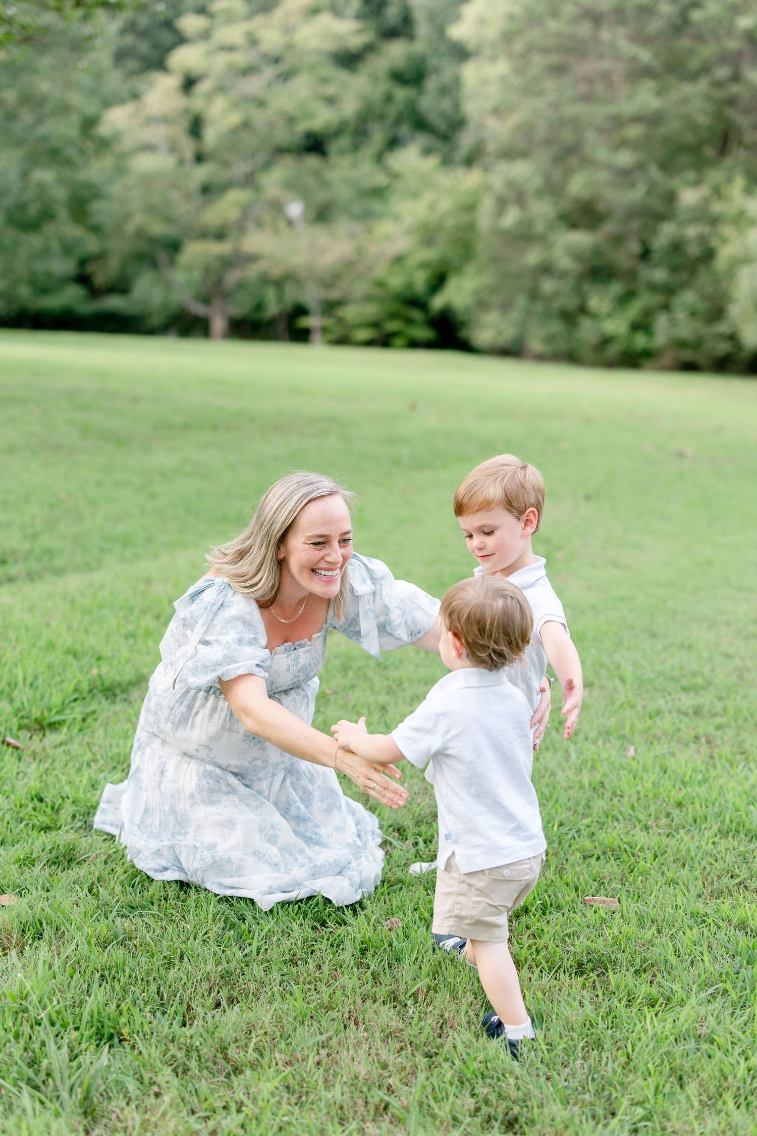 Playful sequence of a mother and child running and playing together in a lush green park setting.