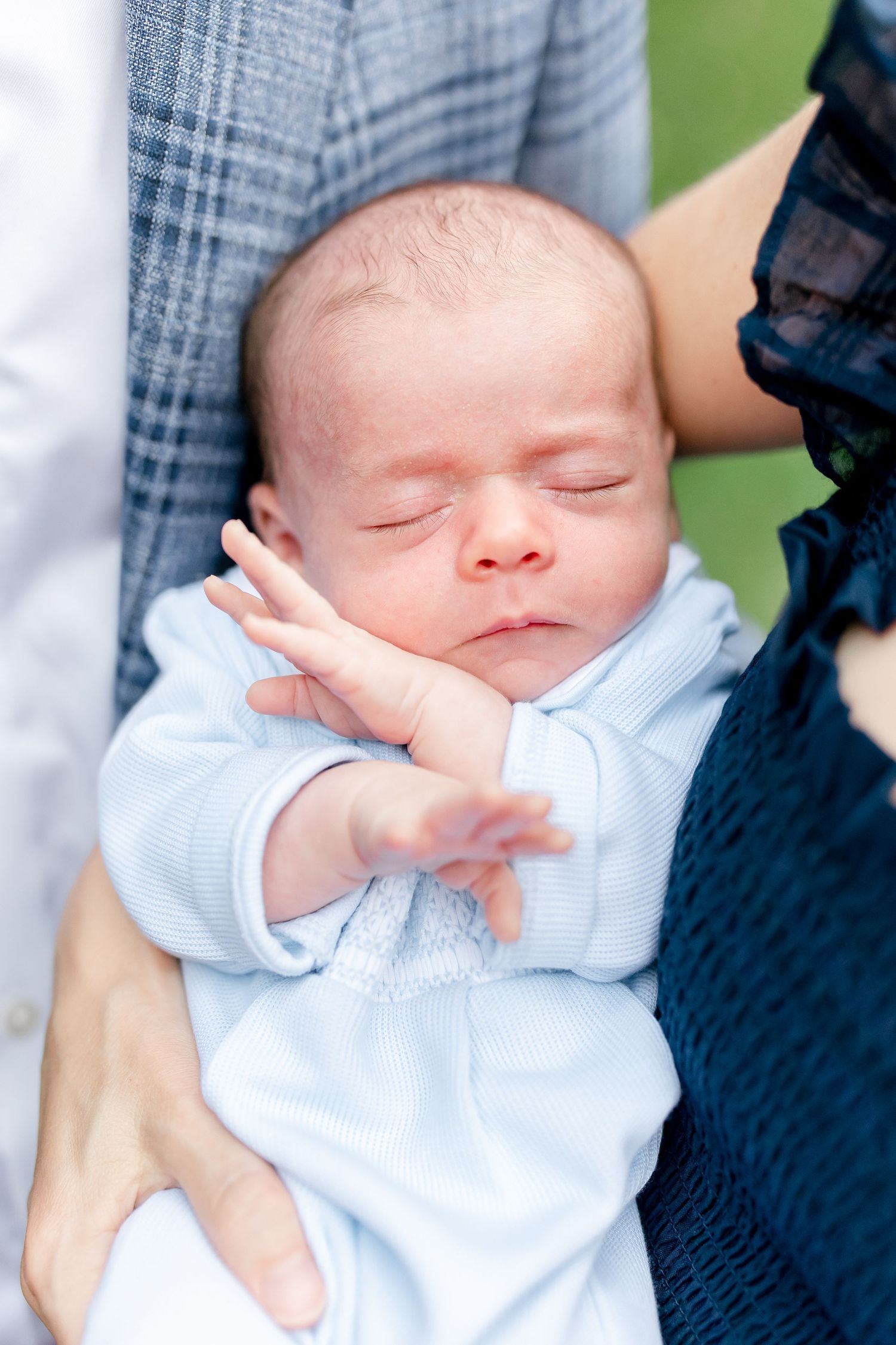 Close-up shots of sleeping newborn baby in light blue outfit.