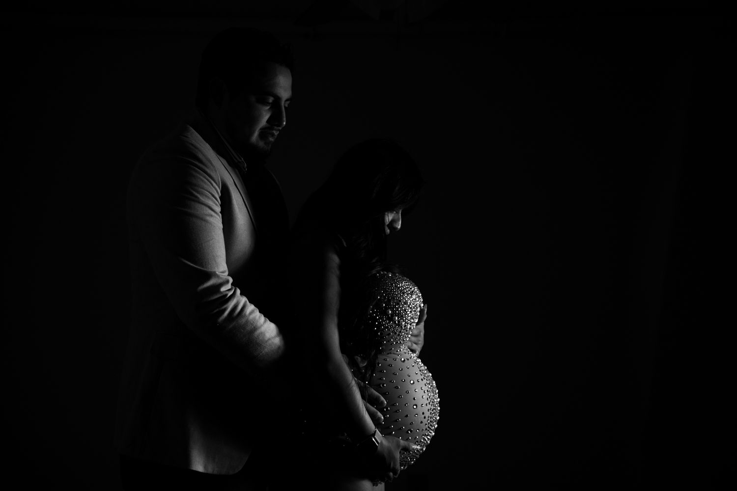 Elegant black and white silhouette portrait of a couple during maternity photoshoot.