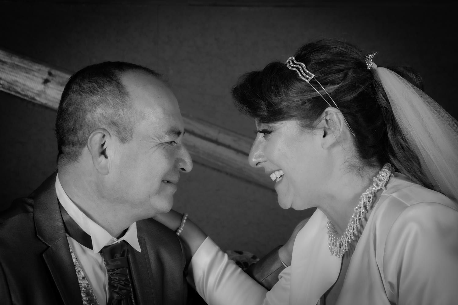 Black and white photo of bride and groom laughing and gazing lovingly at each other.