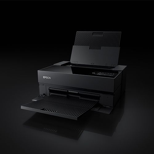 Epson black inkjet photo printer with paper tray open, displayed against a dark background.