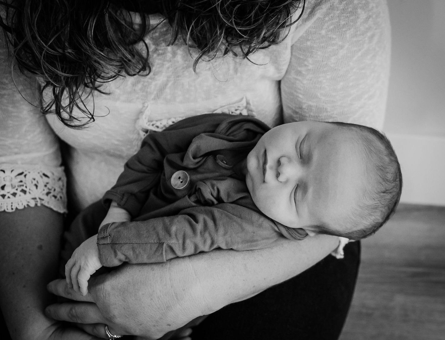 Black and white portrait showing tender moments with sleeping newborn.