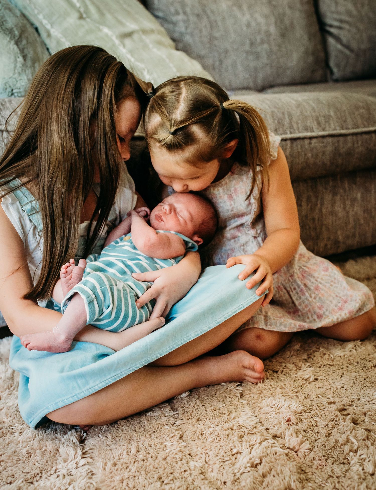 An intimate family moment on a carpeted floor as they admire their newest addition.