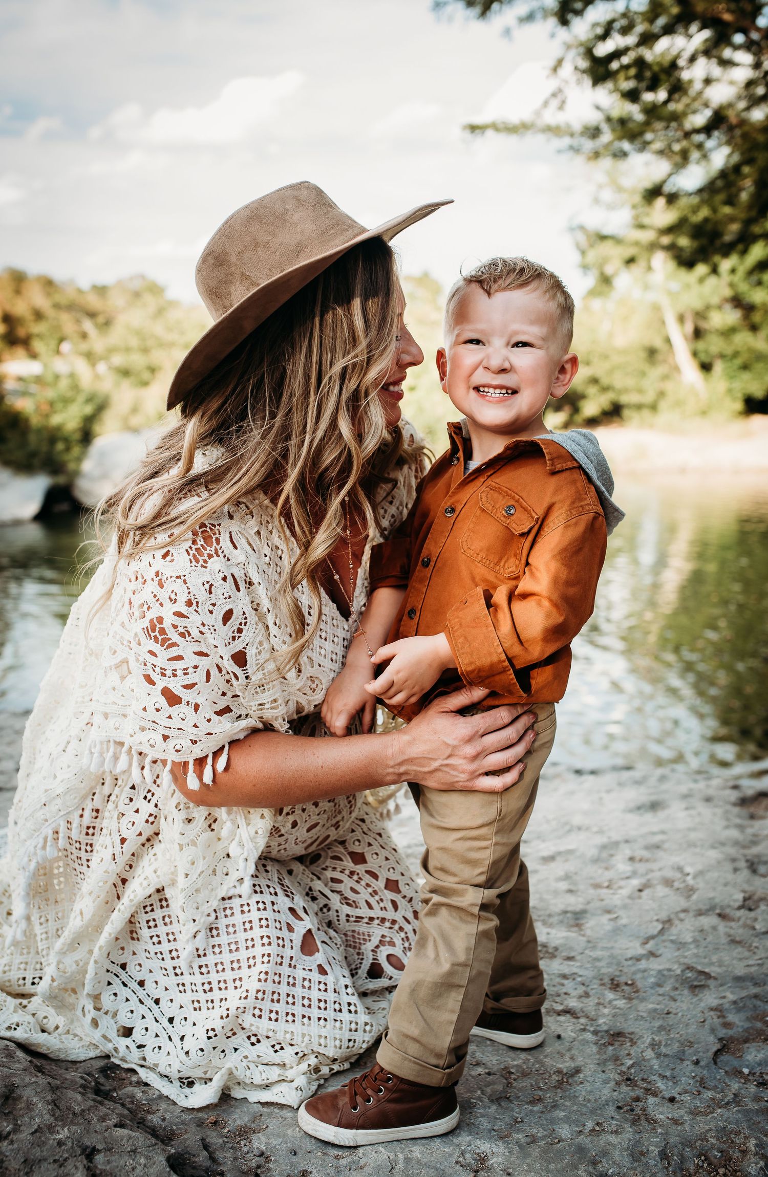 A joyful moment captured in lace dress and autumn attire by the water.