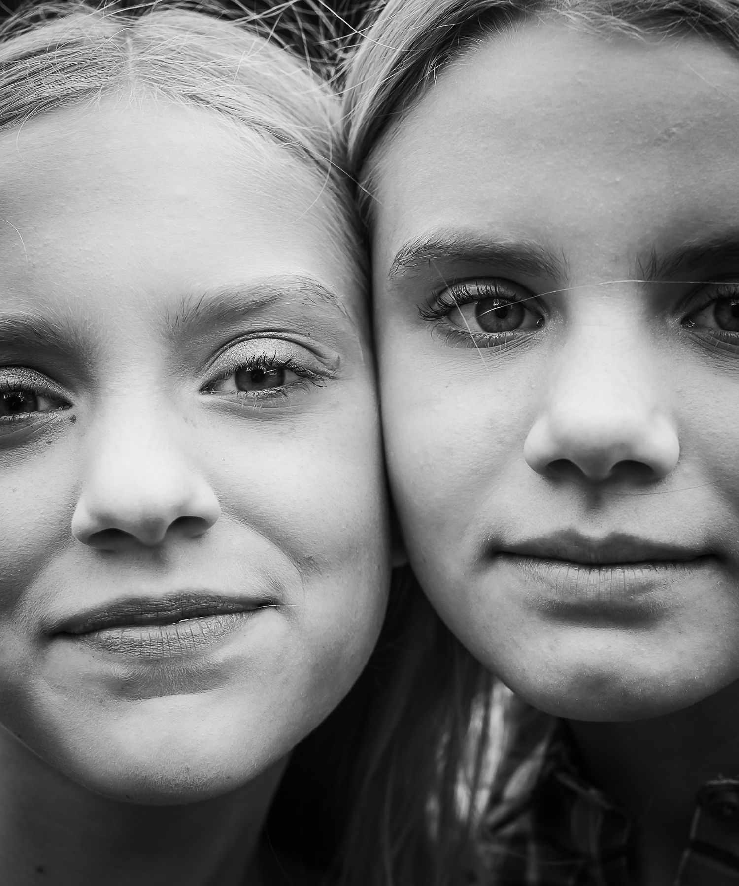 A close-up black and white portrait showing two people side by side.
