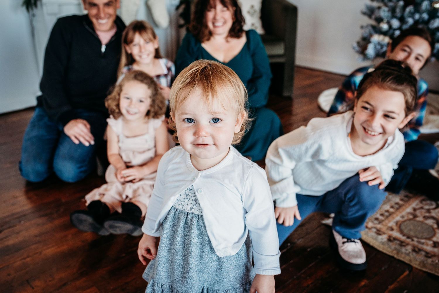 Young children sitting indoors and sharing heartwarming smiles on a brown couch.