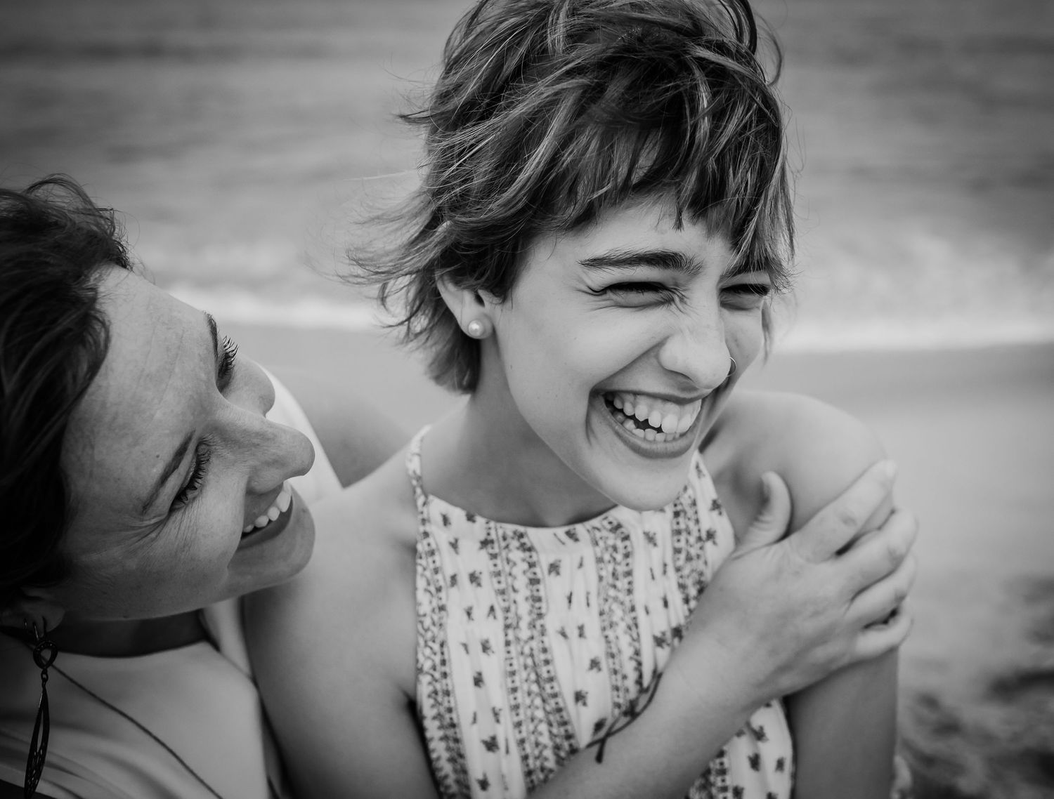 A joyful moment captured at the beach in black and white.