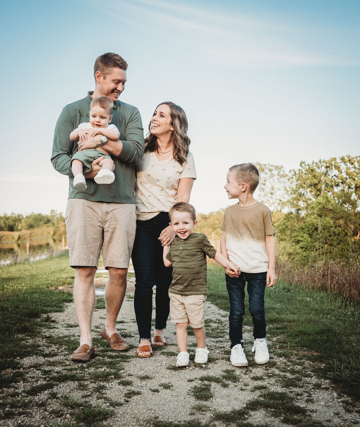 A loving family enjoys a sunny day outdoors together in casual attire.