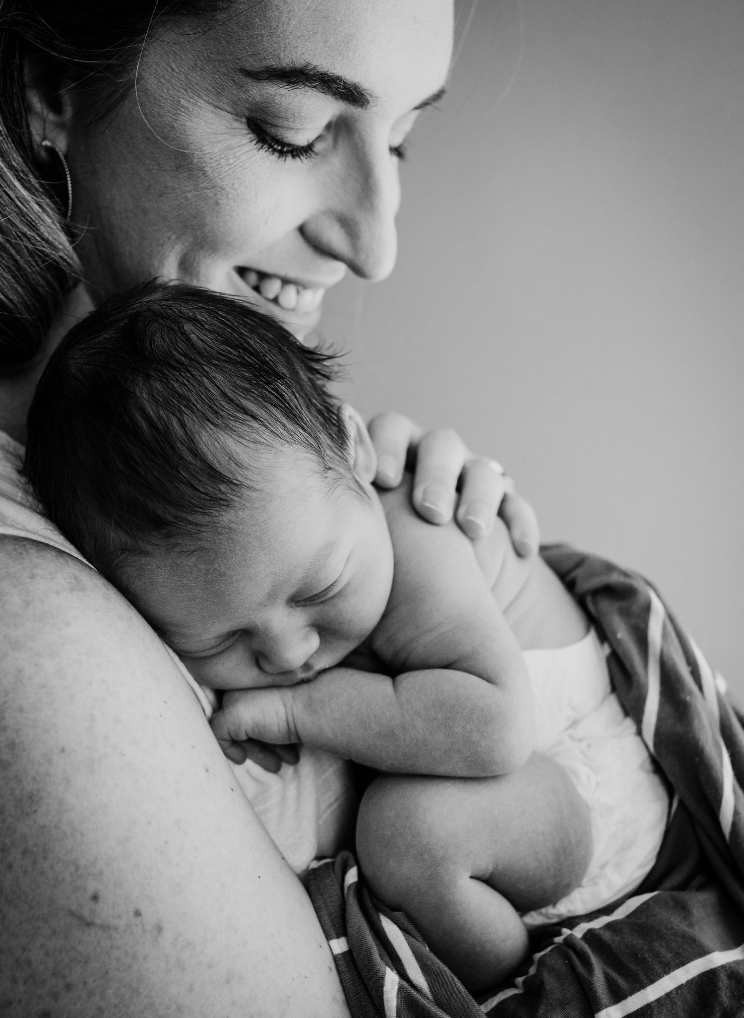 Intimate black and white portrait series showing tender moments of parent and baby bonding.