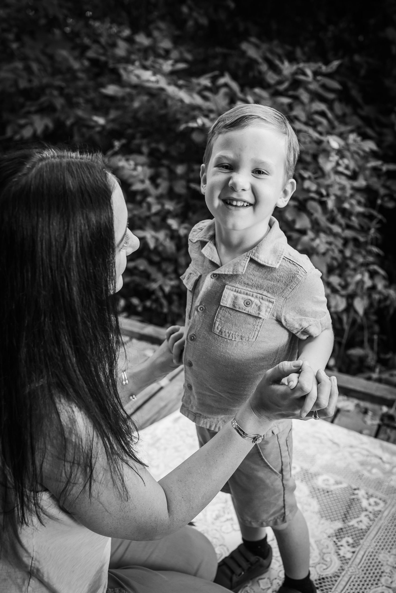 A heartwarming black and white moment between parent and child sharing laughter outdoors.