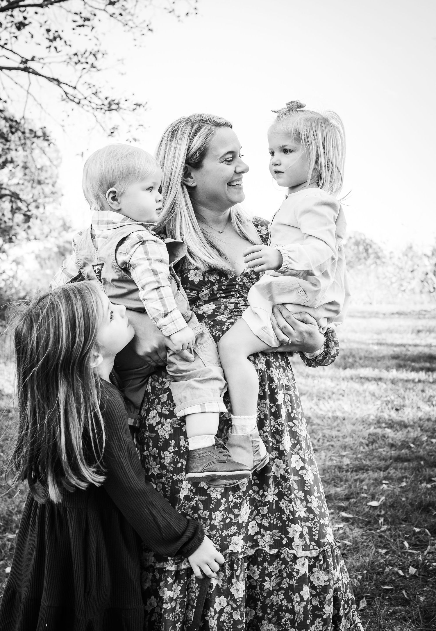 A tender black and white family moment captured outdoors during autumn.