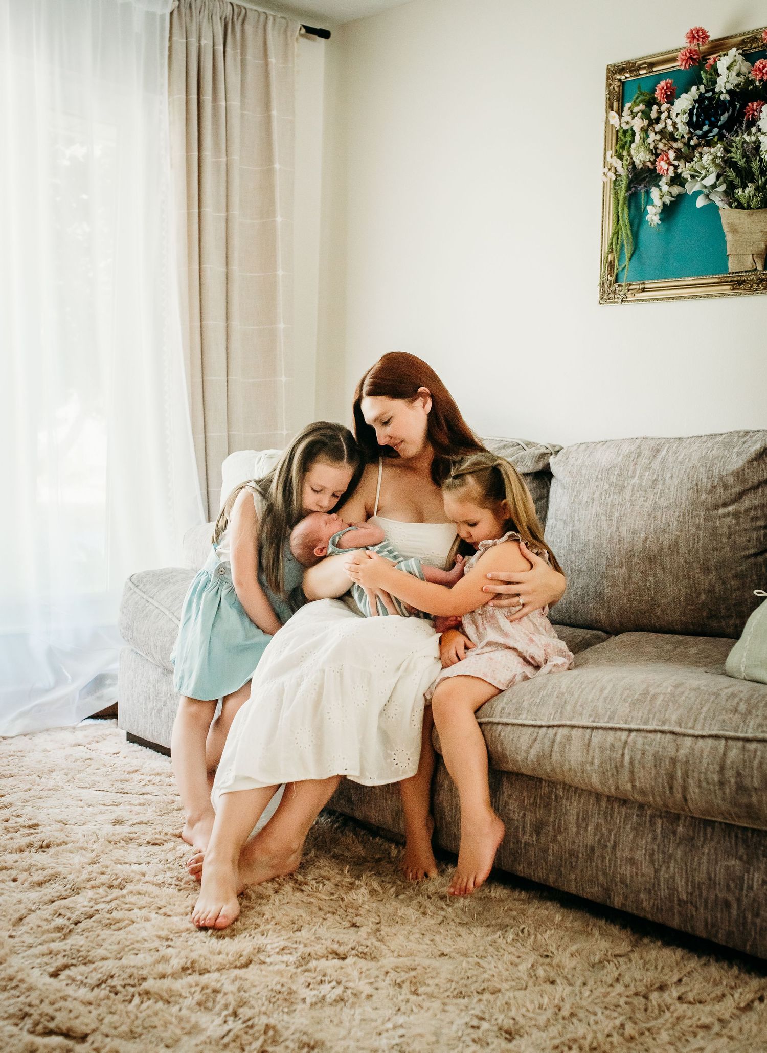 A peaceful family scene on a grey couch as they share a loving moment together.