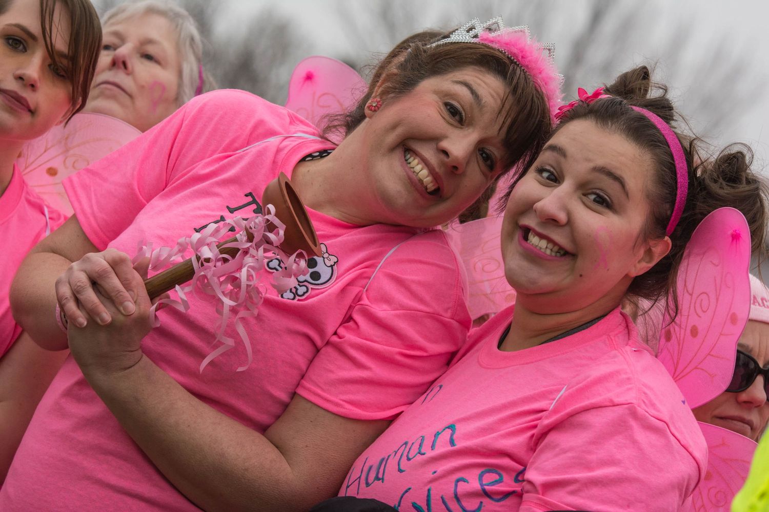 Group wearing matching pink shirts at an outdoor charity event.
