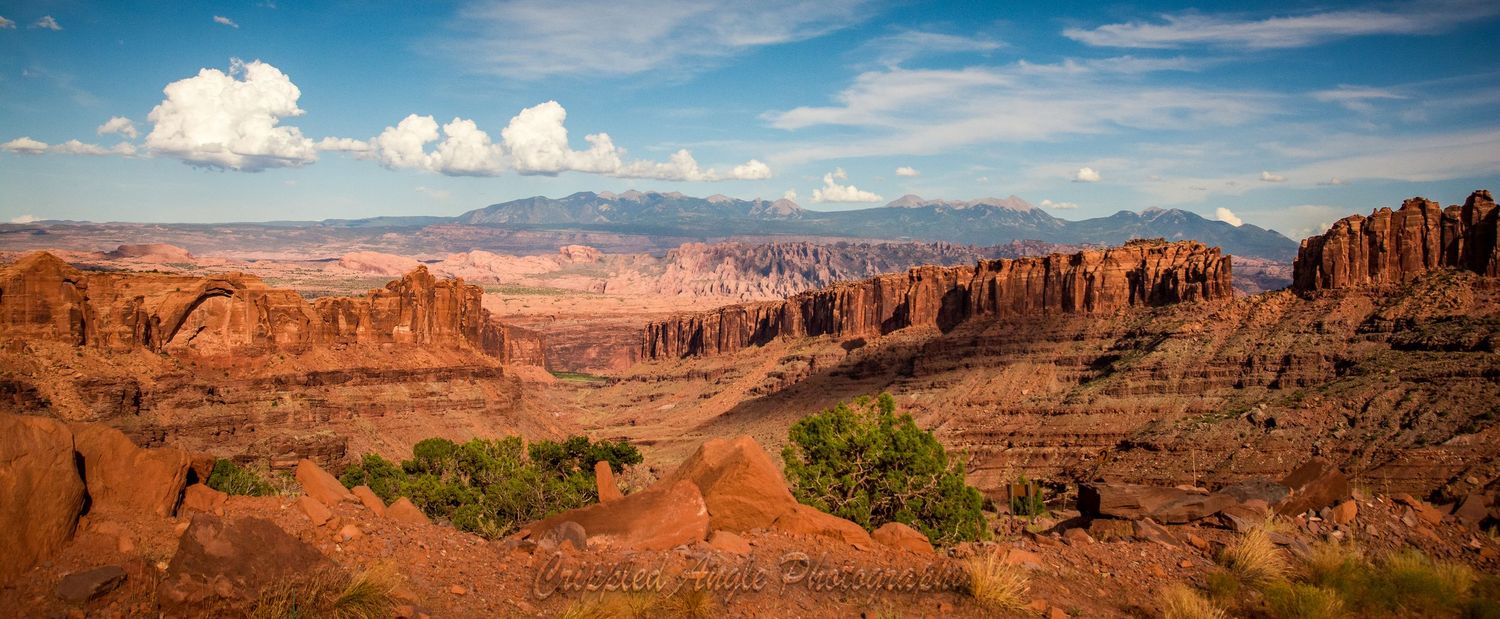 Panoramic view of red rock canyons and cliffs in Utah desert landscape.