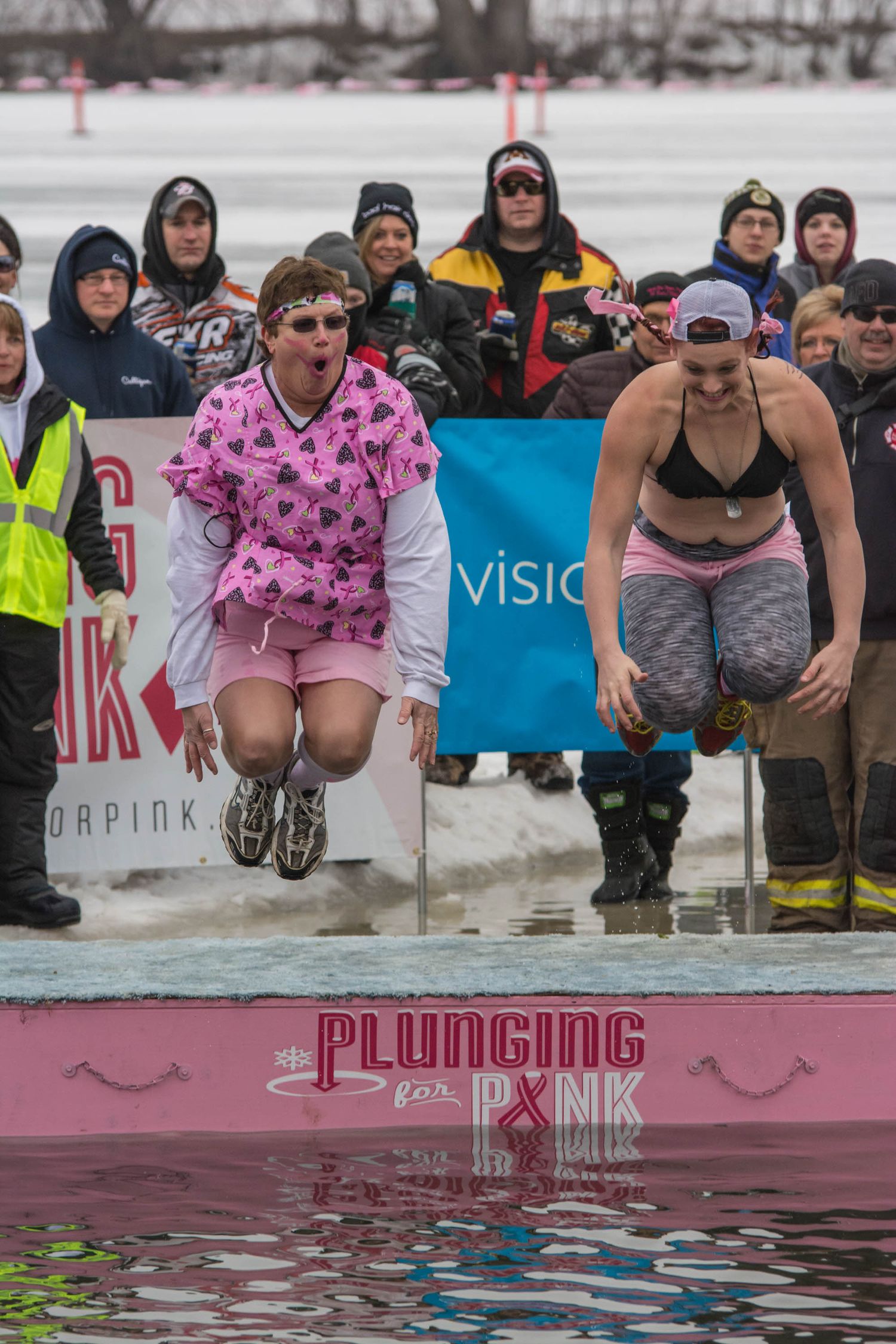 Participants jumping into cold water at a winter polar plunge charity event.