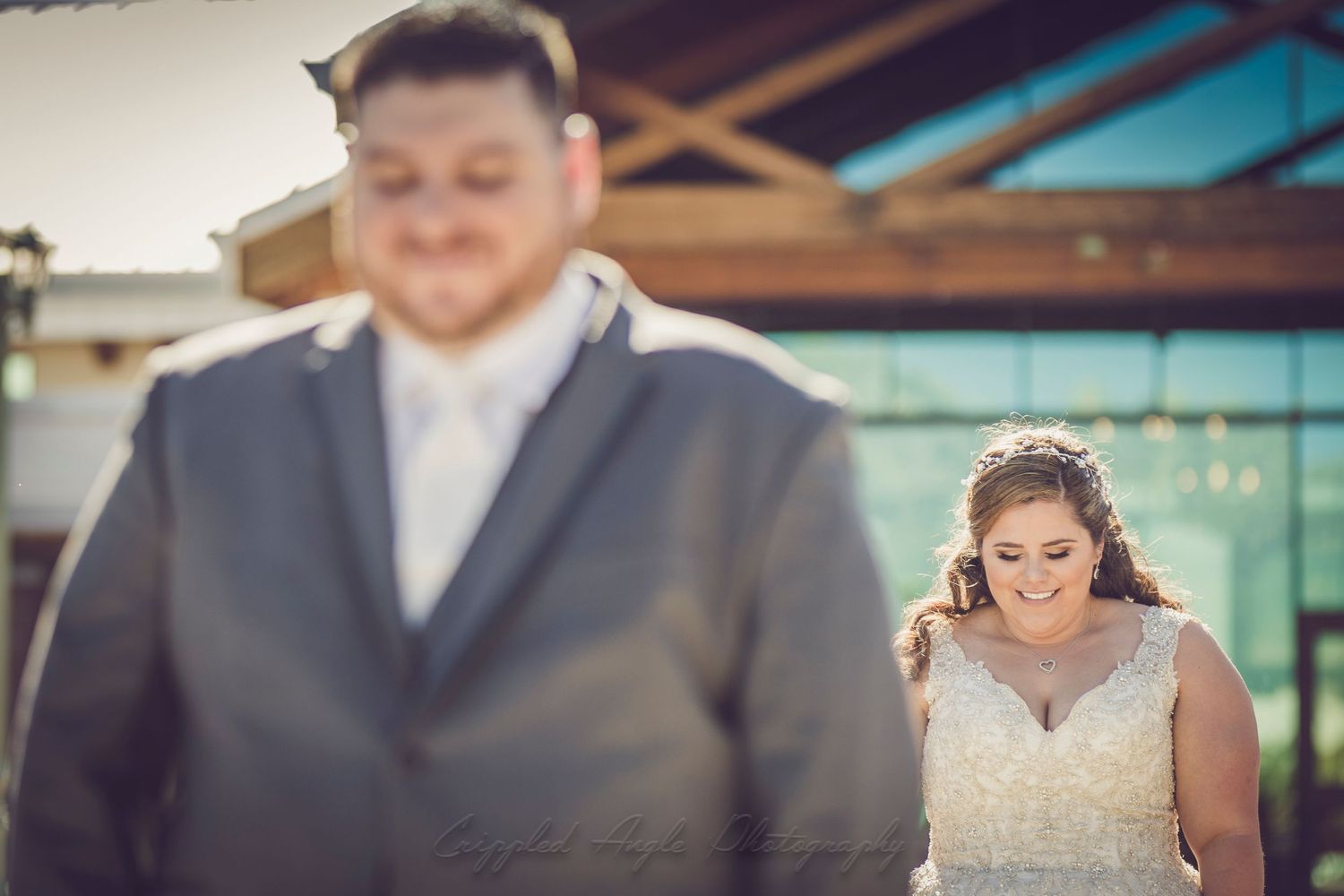 A creative first look wedding photo with focus on the bride's expression.
